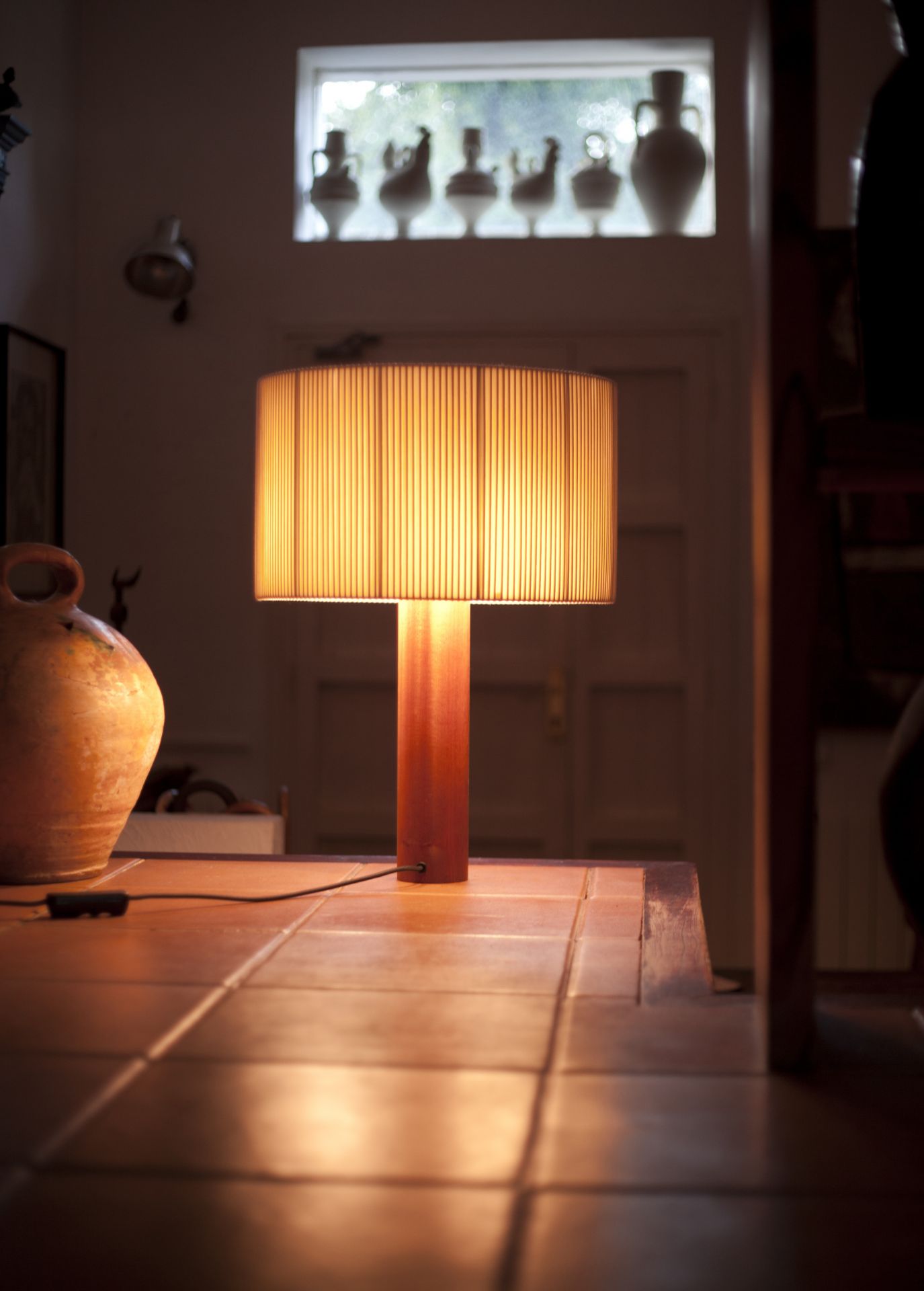 Moragas Lampe von Santa & Cole: Tischleuchte mit Holzfuß und geripptem Lampenschirm, warmes Licht.