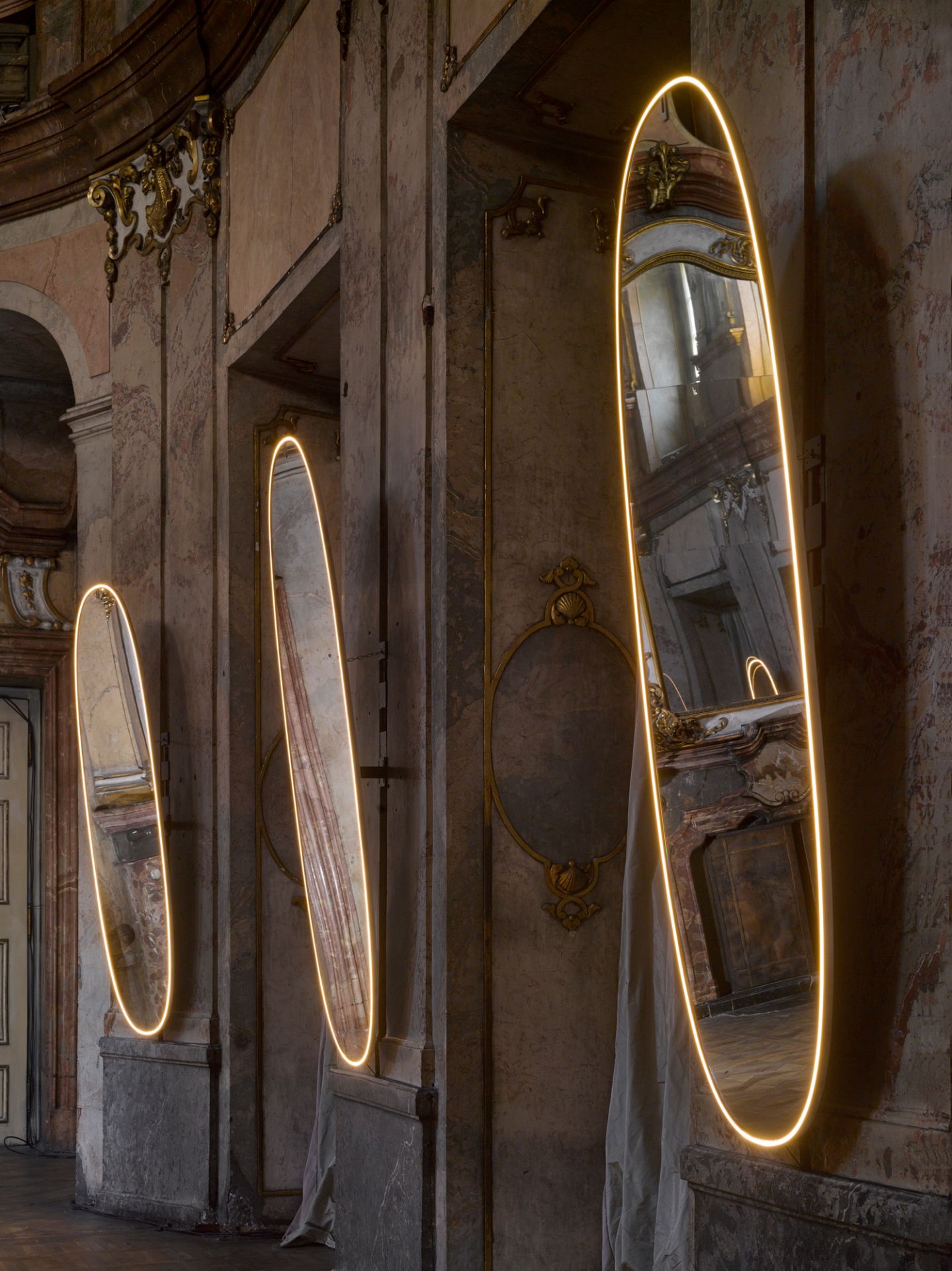 Drei ovale Flos Lichtspiegel "La Plus Belle" aus Aluminium mit LED-Rahmen an Wand.