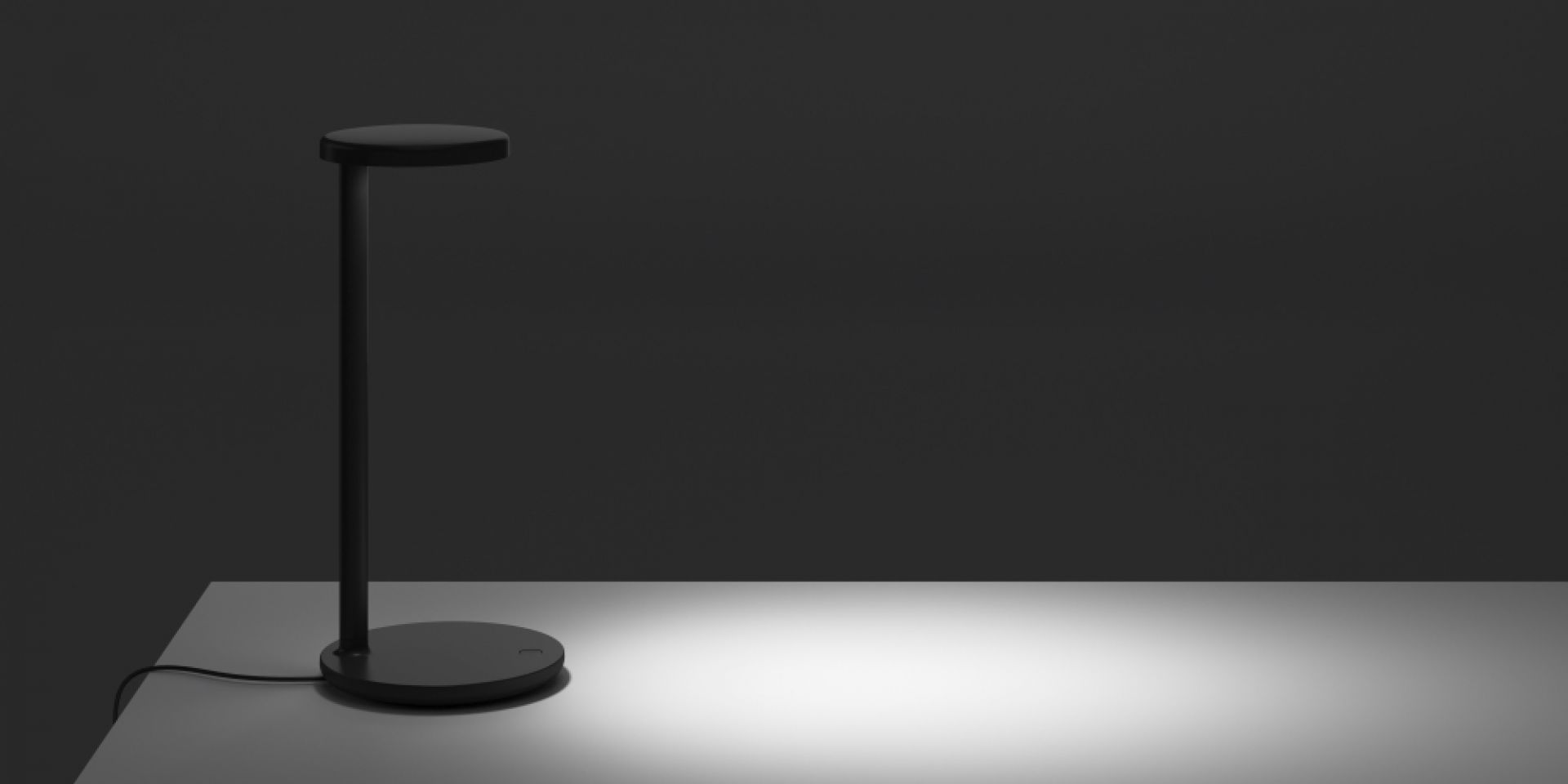 Schwarze Oblique Tischleuchte von Flos mit runder Basis und flachem Lampenschirm, modernes Design.