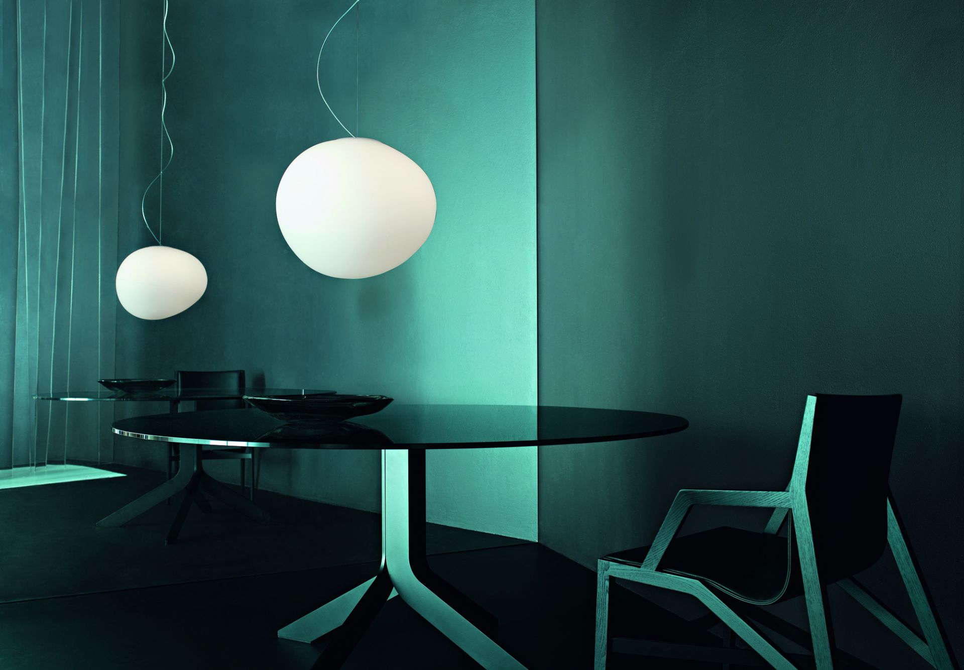 Zwei Gregg Pendelleuchten von Foscarini über einem Esstisch in modernem Ambiente. Designleuchte für Wohnraum.