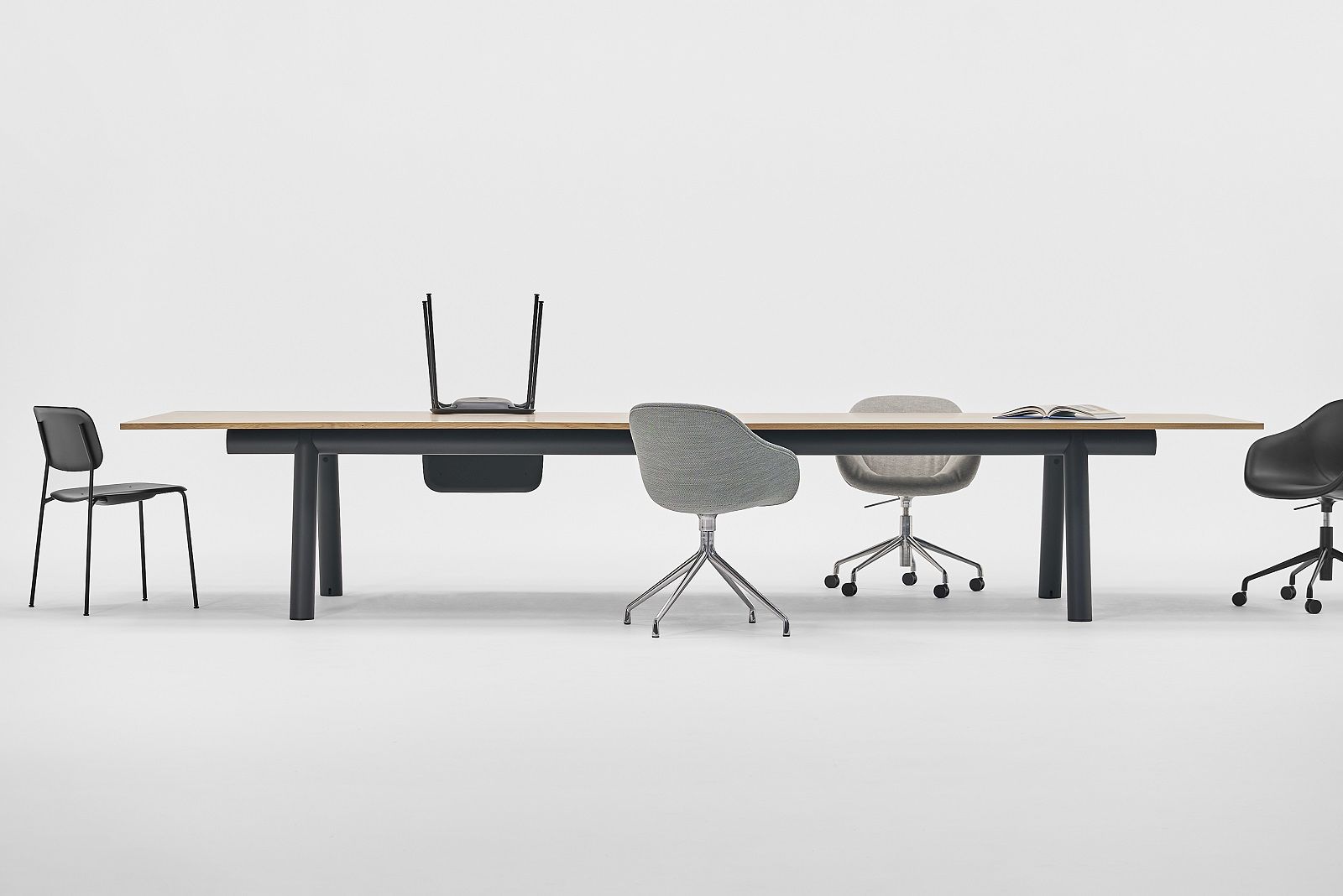 Hay Boa Table Konferenztisch mit Stühlen in verschiedenen Farben vor einem weißen Hintergrund.