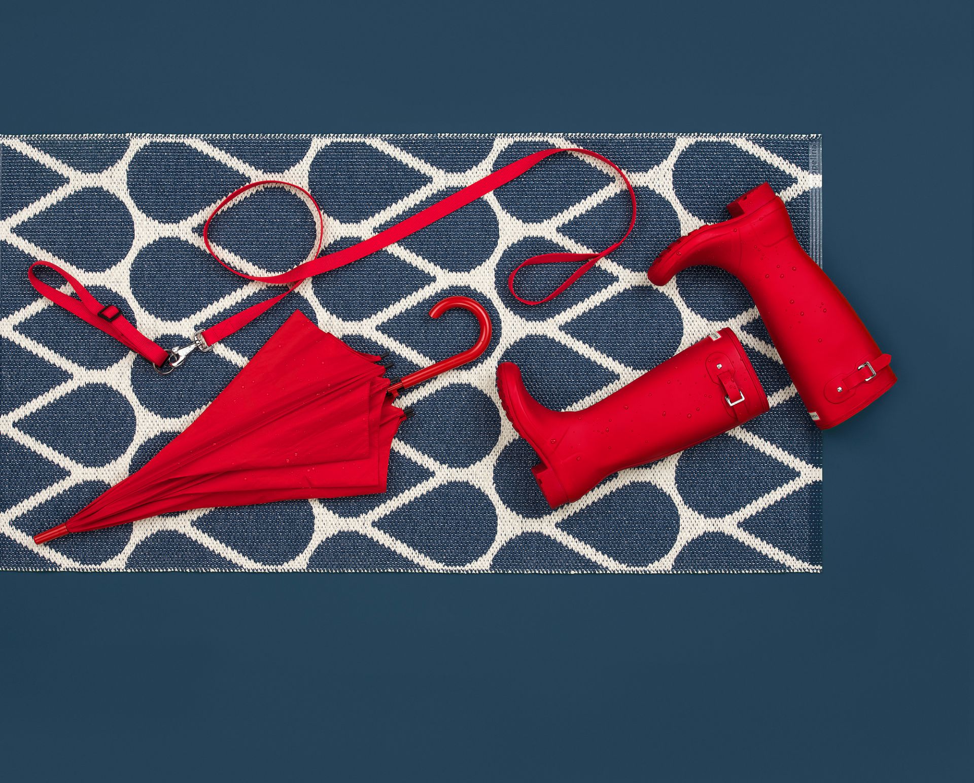 Otis Kunststoffteppich von Pappelina, 70x140 cm, blau-weiß mit Regenschirm, Leine und Gummistiefel.