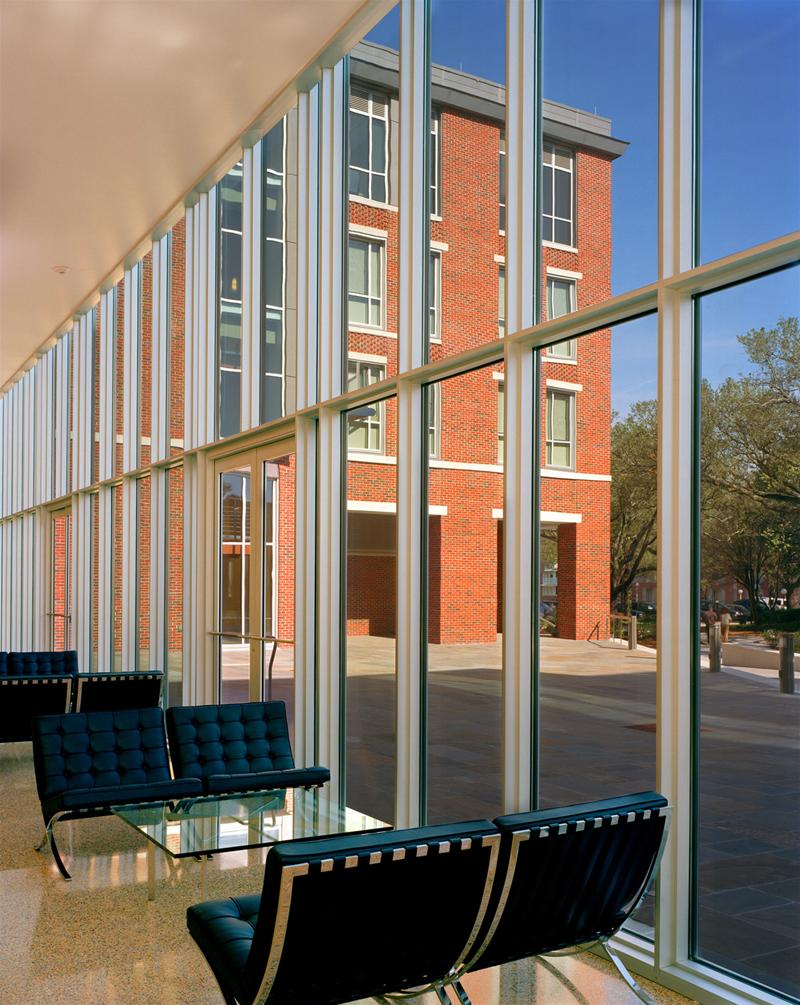 Barcelona Sessel: Schwarze Ledersessel mit Glas-Couchtisch vor einer Fensterfront. Knoll International Design.