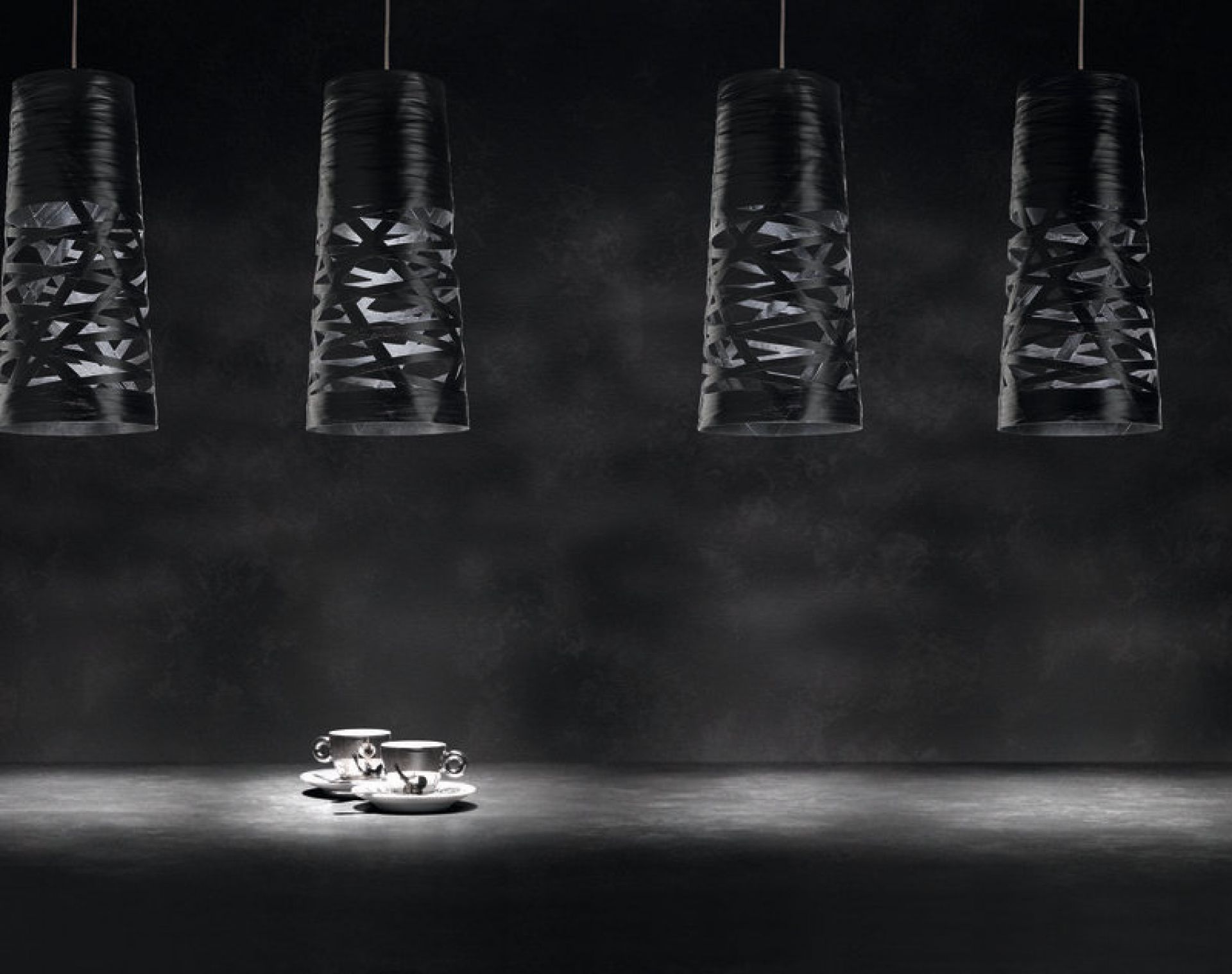 Vier schwarze Tress Mini Pendelleuchten von Foscarini mit modernem Design über zwei Kaffeetassen.
