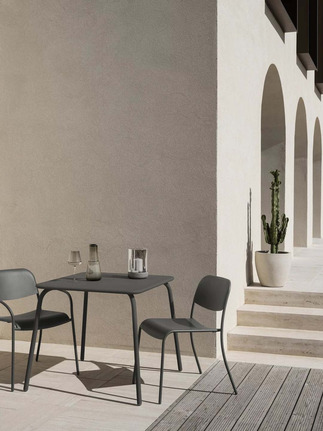 Blomus Yua Armlehnstuhl Outdoor mit Tisch auf Terrasse, minimalistisches Design für Garten und Balkon.