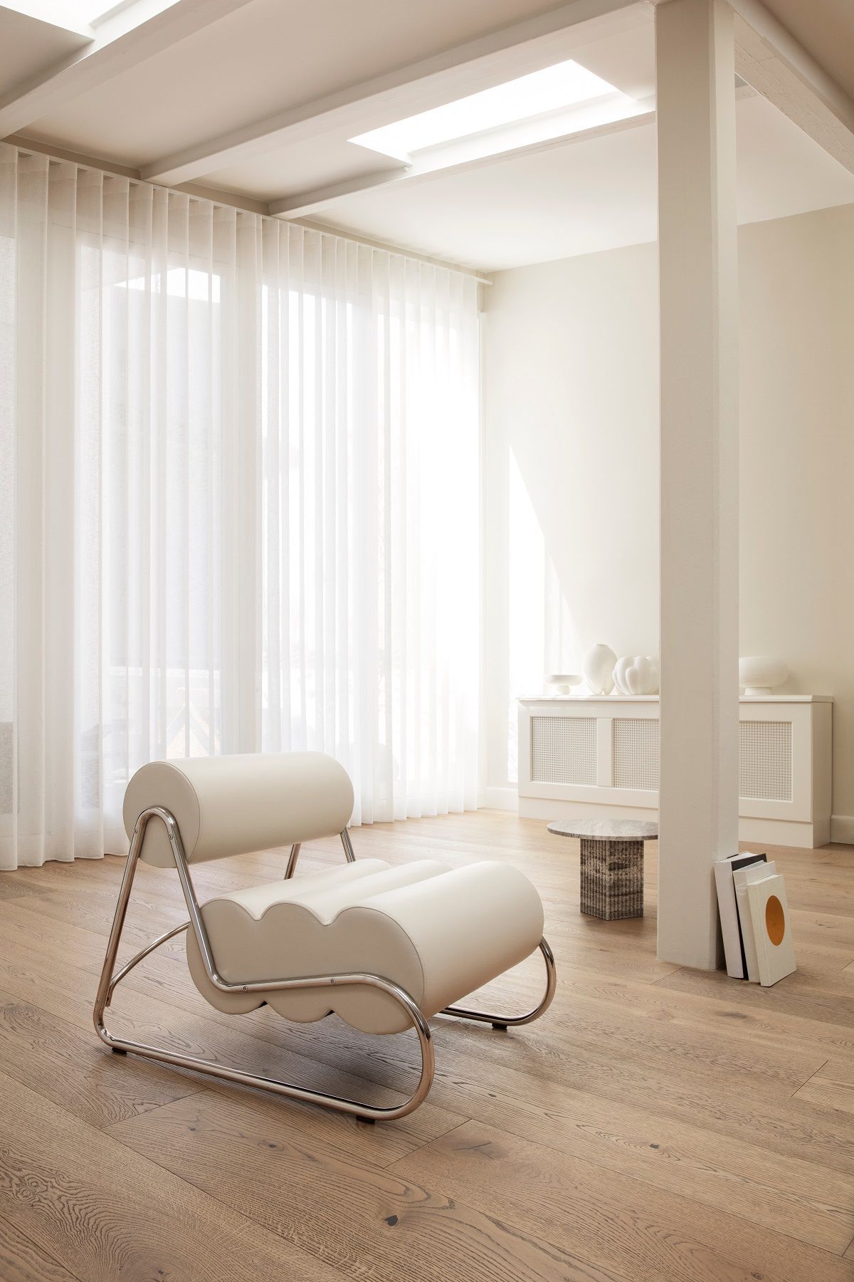 Fave Armchair Sessel von NORR11: Moderner Sessel mit Chromgestell und cremefarbener Polsterung im Wohnzimmer.