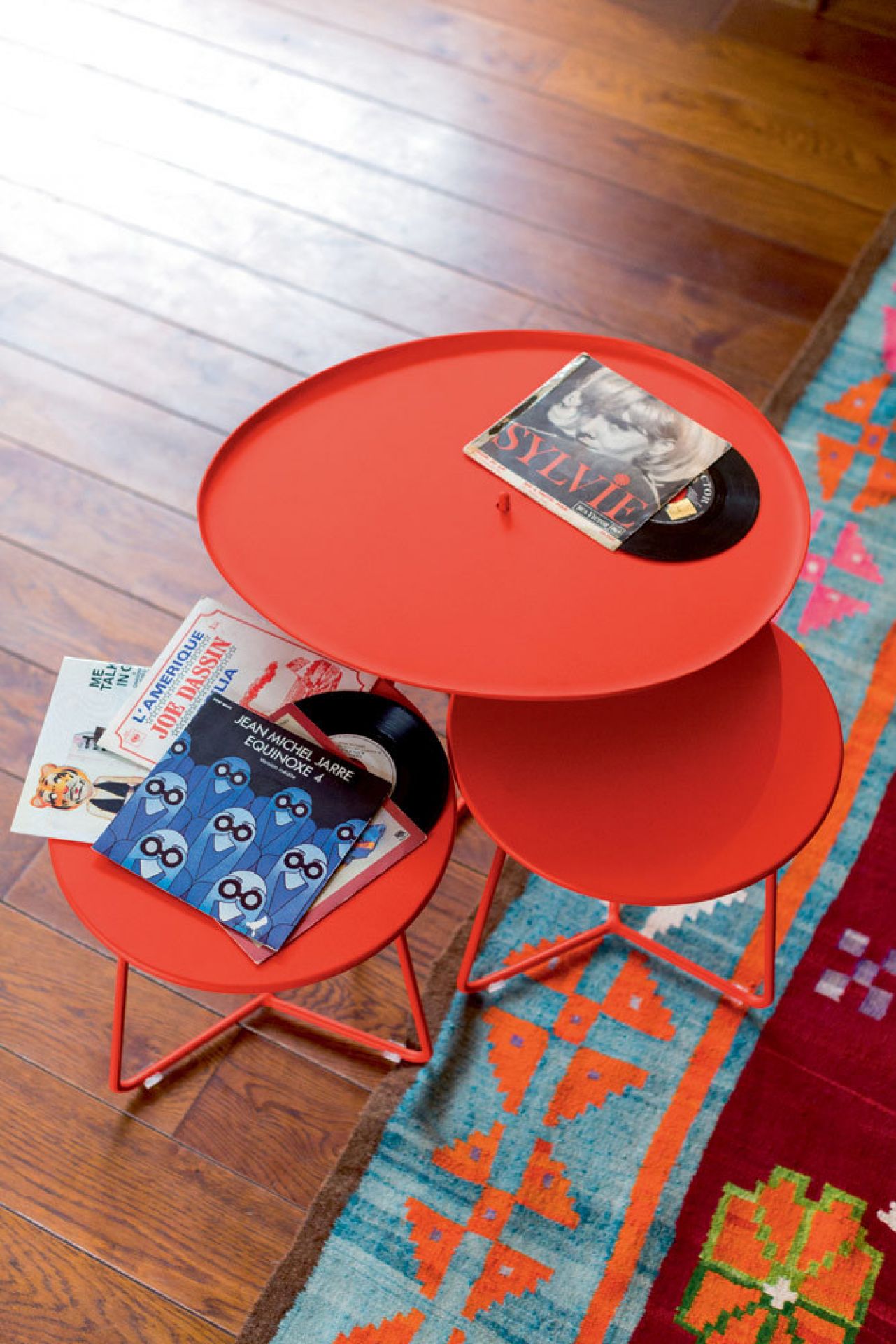 Roter Cocotte Beistelltisch von Fermob, ideal für den Garten oder Balkon, mit Schallplatten.