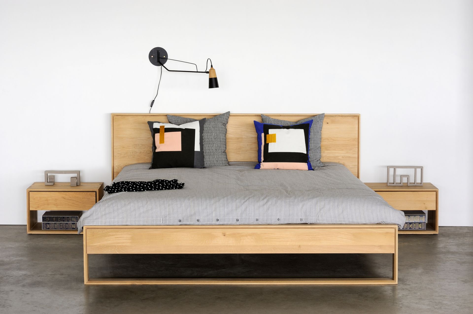 Nordic II Bett von Ethnicraft aus Eiche mit Nachttischen und moderner Bettwäsche.