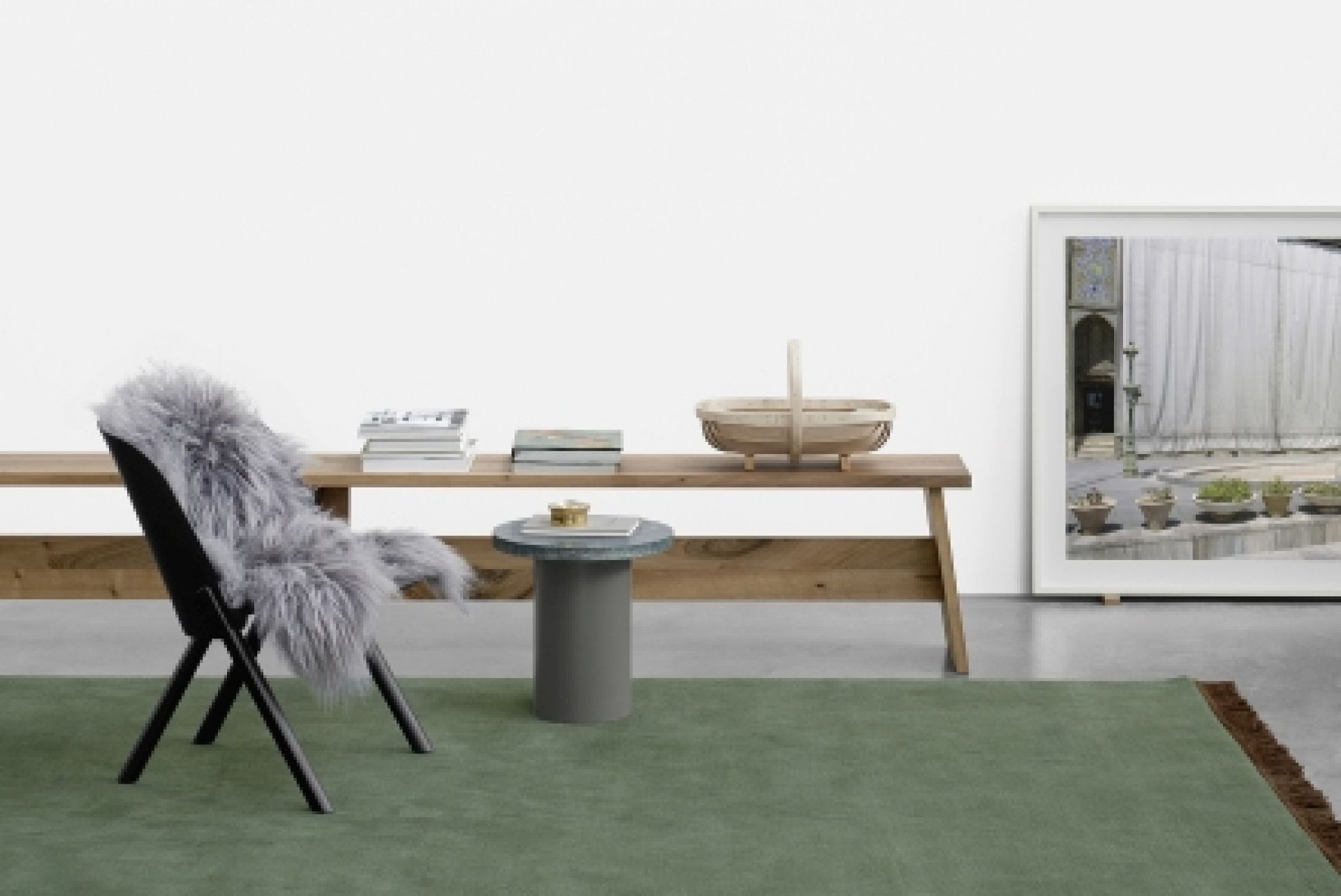 EC05 That Sessel e15 mit grauem Fell, Holztisch und grünem Teppich in minimalistischem Raum.