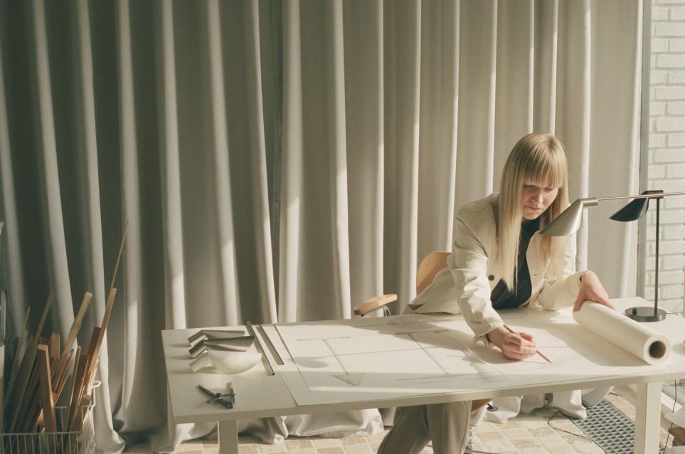 Frau arbeitet unter einer MS Tischleuchte von Fritz Hansen, Aluminium PVD schwarz.