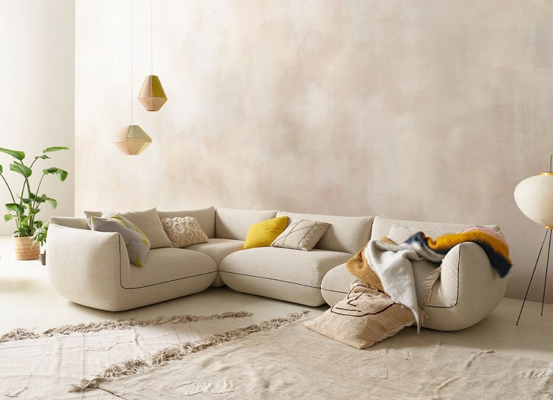 Hellgraues Jalis Sofa von Cor, ein modernes Ecksofa mit Kissen und Decken.