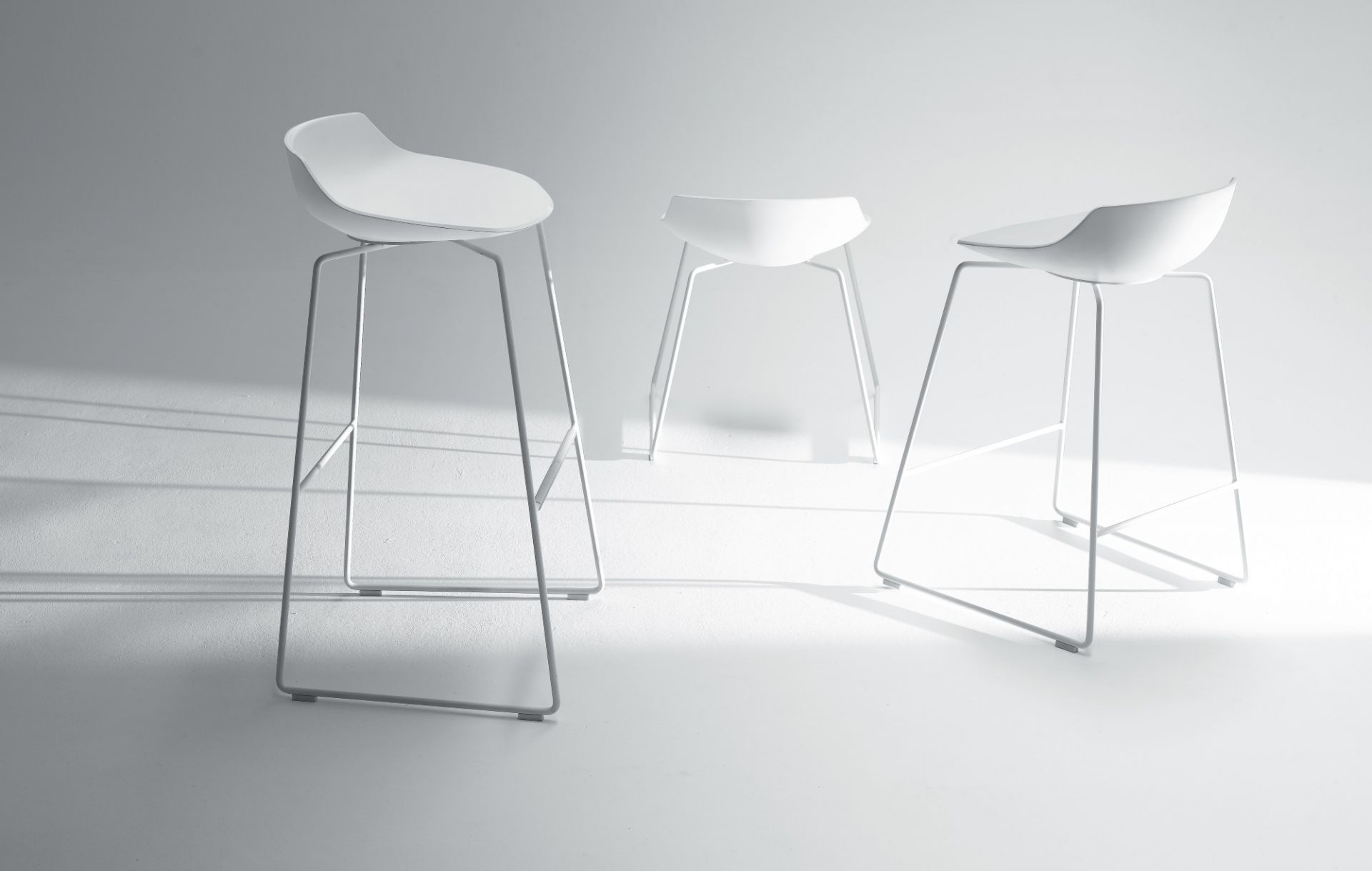 Drei weiße Flow Stool Hocker von MDF Italia mit minimalistischem Design und Stahlgestell.