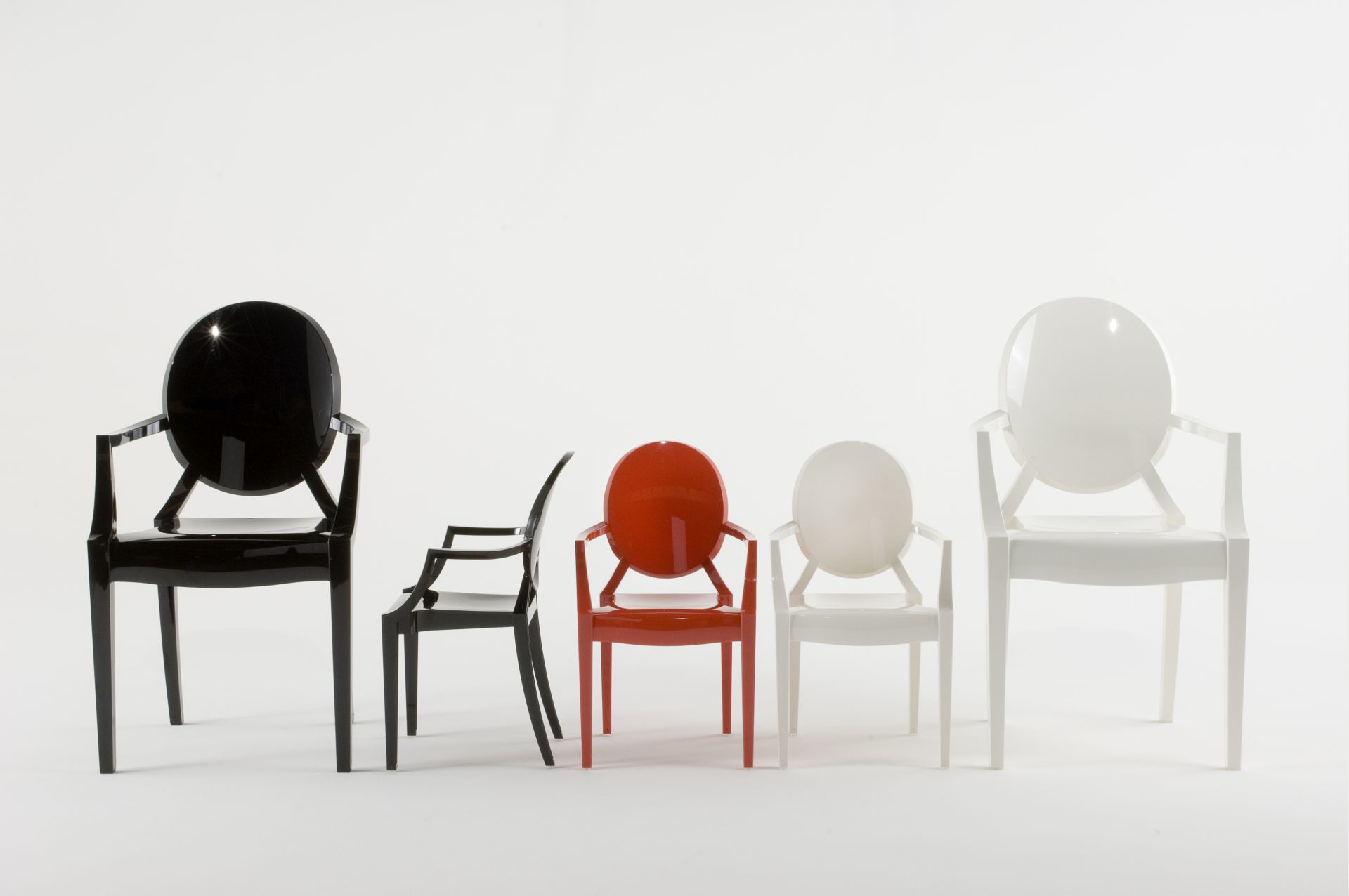 Fünf Lou Lou Ghost Kinderstühle von Kartell in Schwarz, Rot und Weiß auf weißem Hintergrund.
