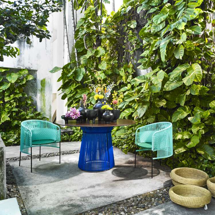 Caribe Lounge Chair Outdoor Sessel in Türkis mit passendem Tisch im Garten.