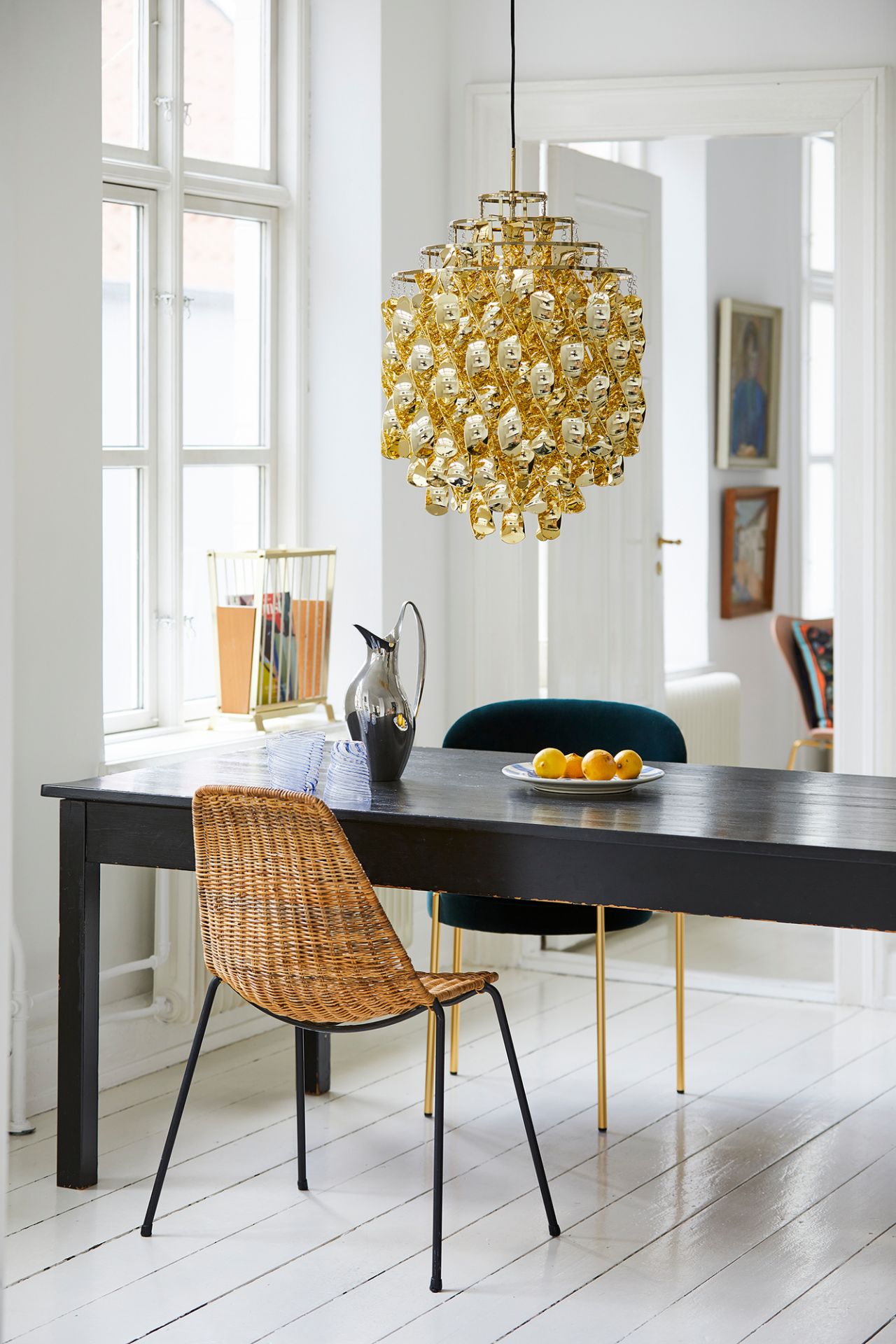 Goldene Spiral Pendelleuchte von Verpan über einem Esstisch in einem hellen Raum.