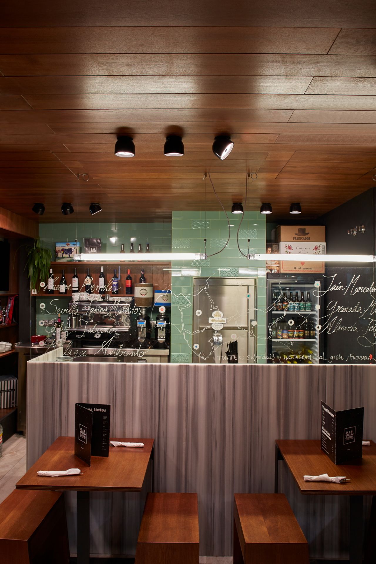 Nahaufnahme von mehreren schwarzen Wan C/W Deckenleuchten von Flos an einer Holzdecke in einem Restaurant.