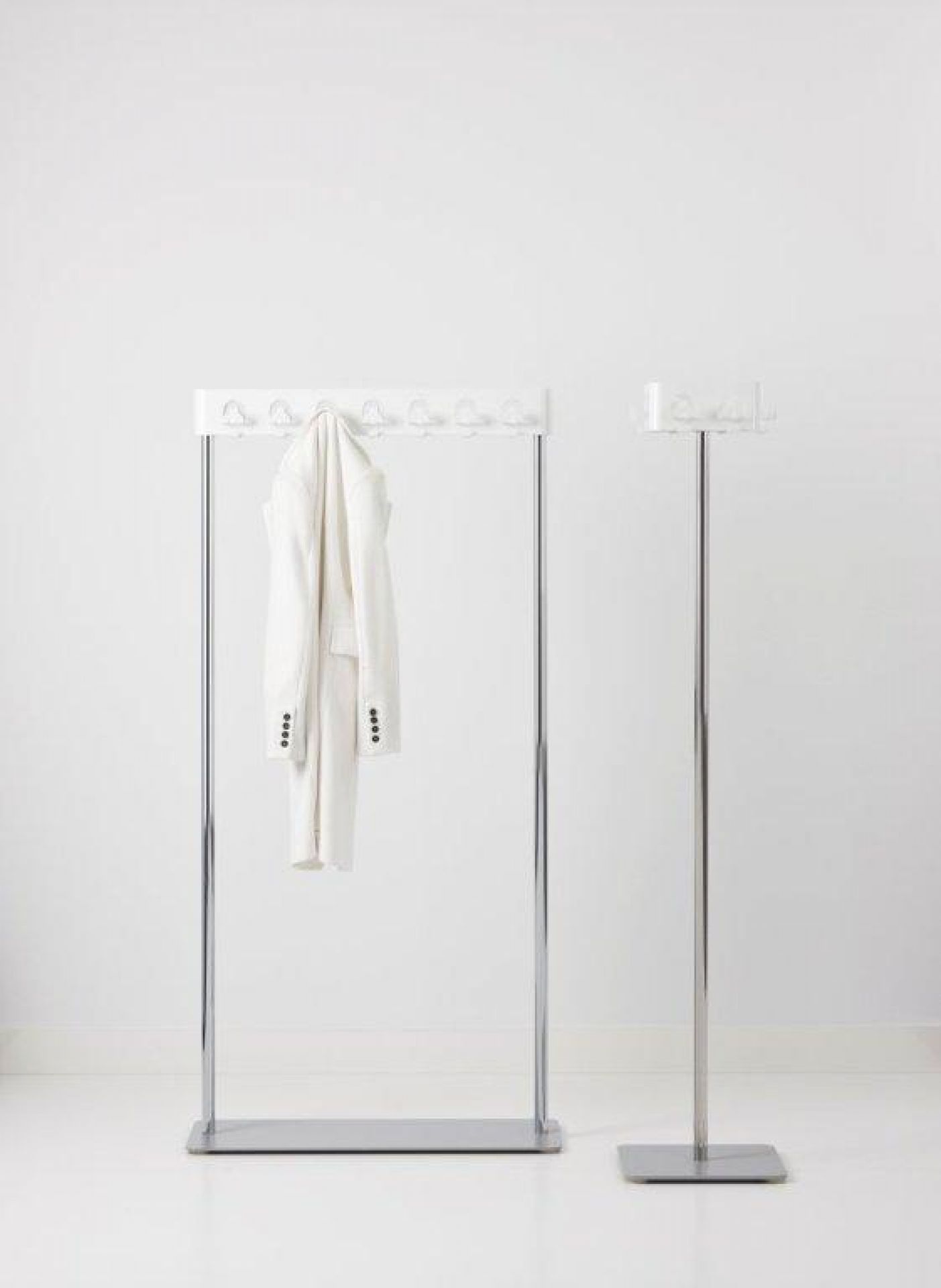 Flow Square Garderobenständer von Cascando: Moderner Garderobenständer aus Chrom mit weißem Aufhänger und weißem Blazer.