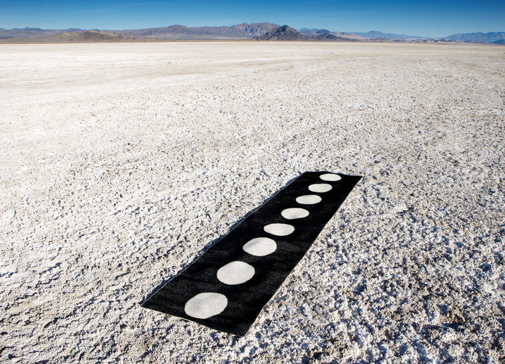 Vera Kunststoffteppich 70x300 cm Pappelina, schwarzer Teppich mit weißen Punkten auf einer weißen Fläche.