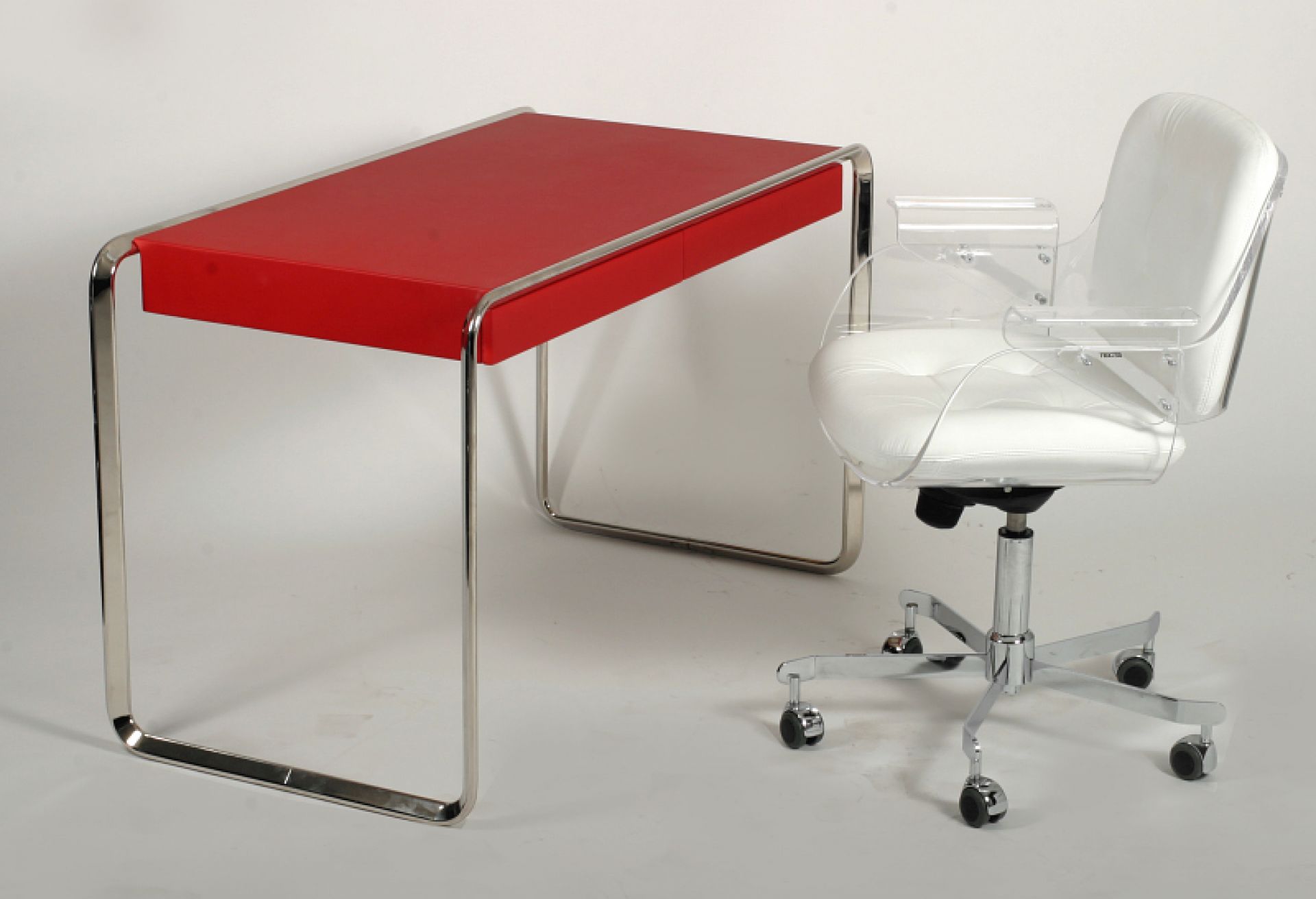 K2D Oblique Schreibtisch von Tecta mit roter Tischplatte und verchromtem Gestell, kombiniert mit Bürostuhl.