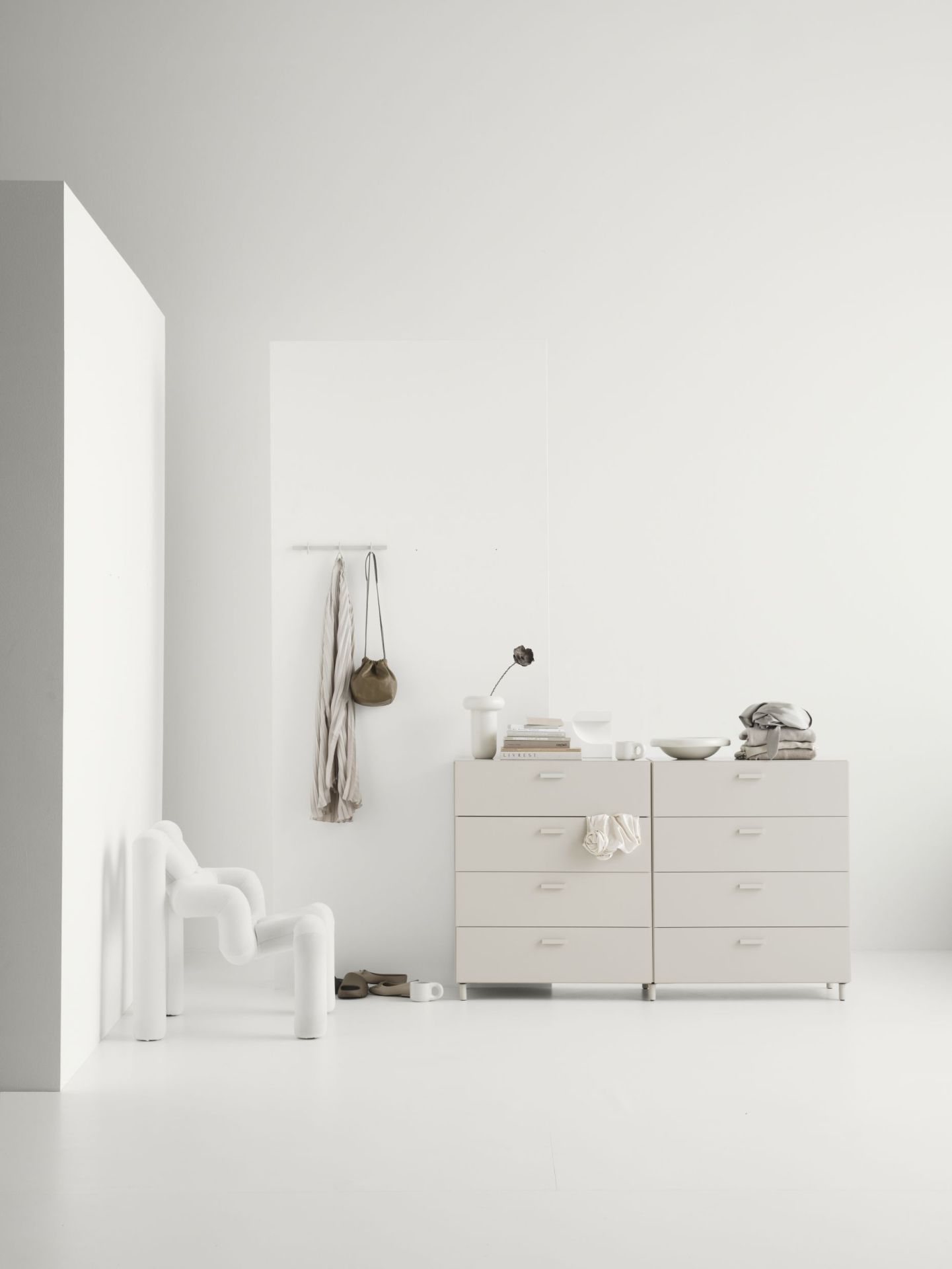 Helles Interieur mit minimalistischer Relief Kommode von String Furniture und dekorativen Accessoires.
