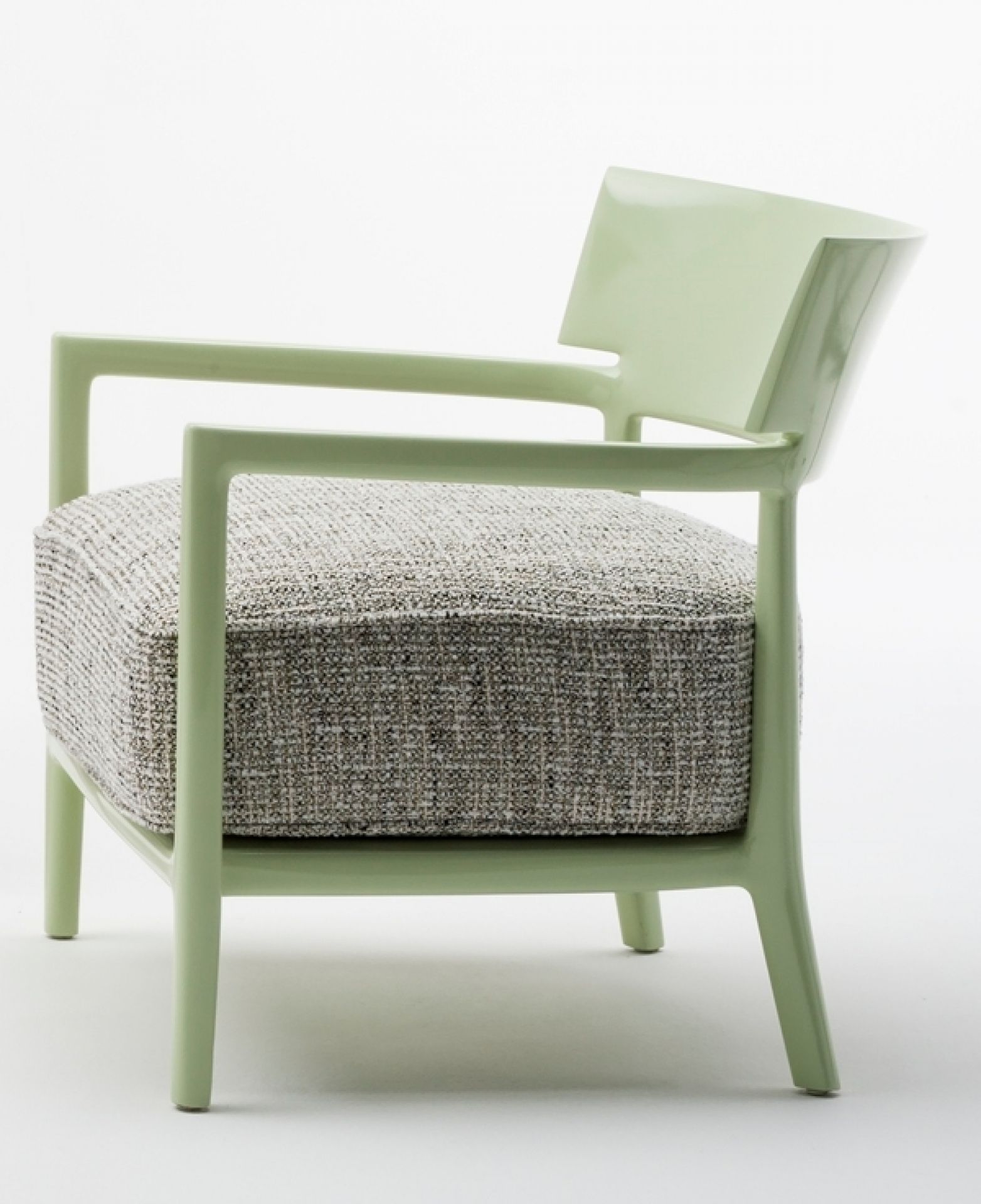 Blassgrüner Cara Sessel von Kartell mit grau meliertem Sitzkissen, seitliche Ansicht. Design Sessel für Wohnzimmer.