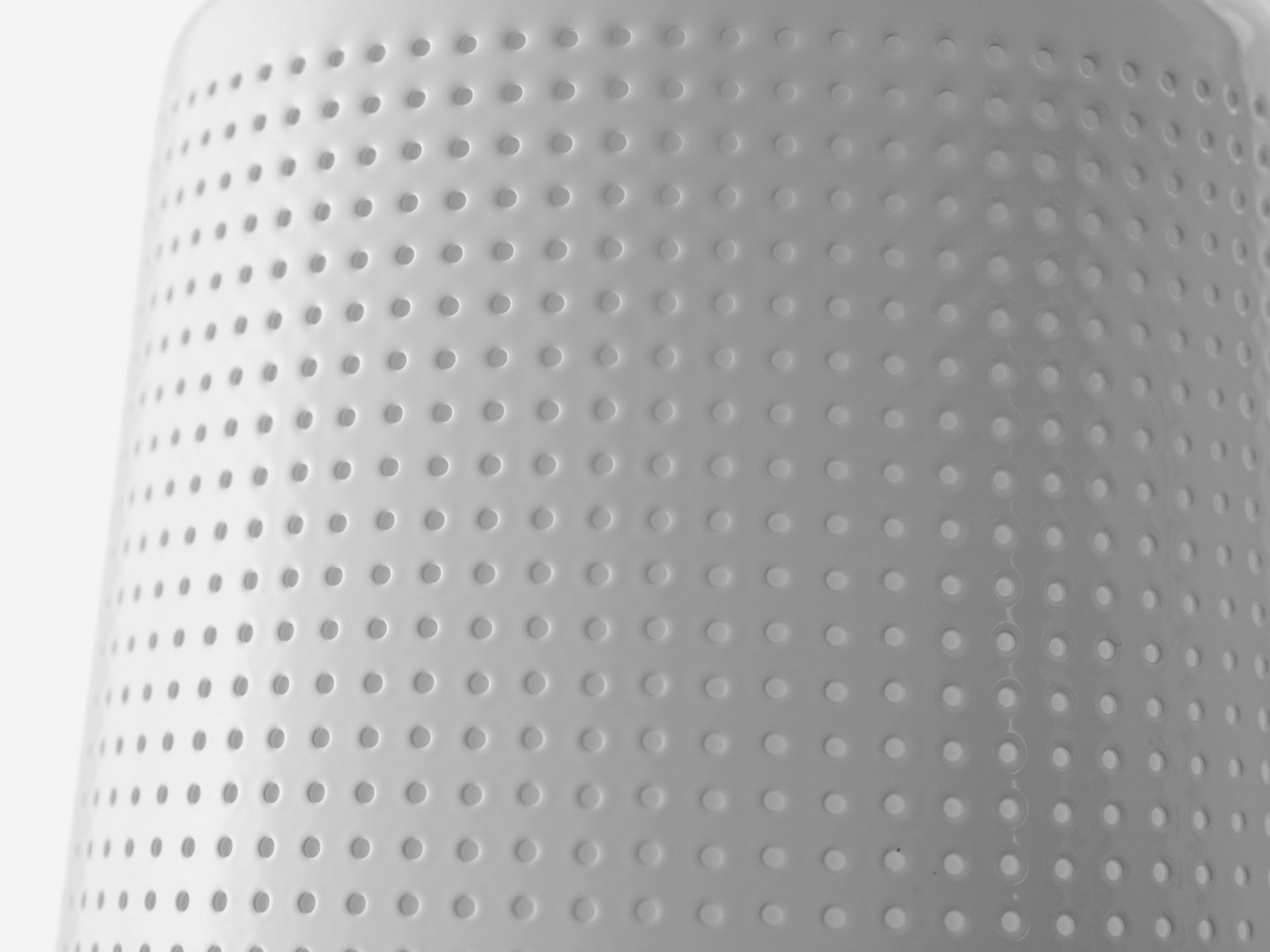 Detailaufnahme der weißen Vipp Wandspot Lampe mit charakteristischem, perforiertem Lampenschirm für indirekte Beleuchtung.