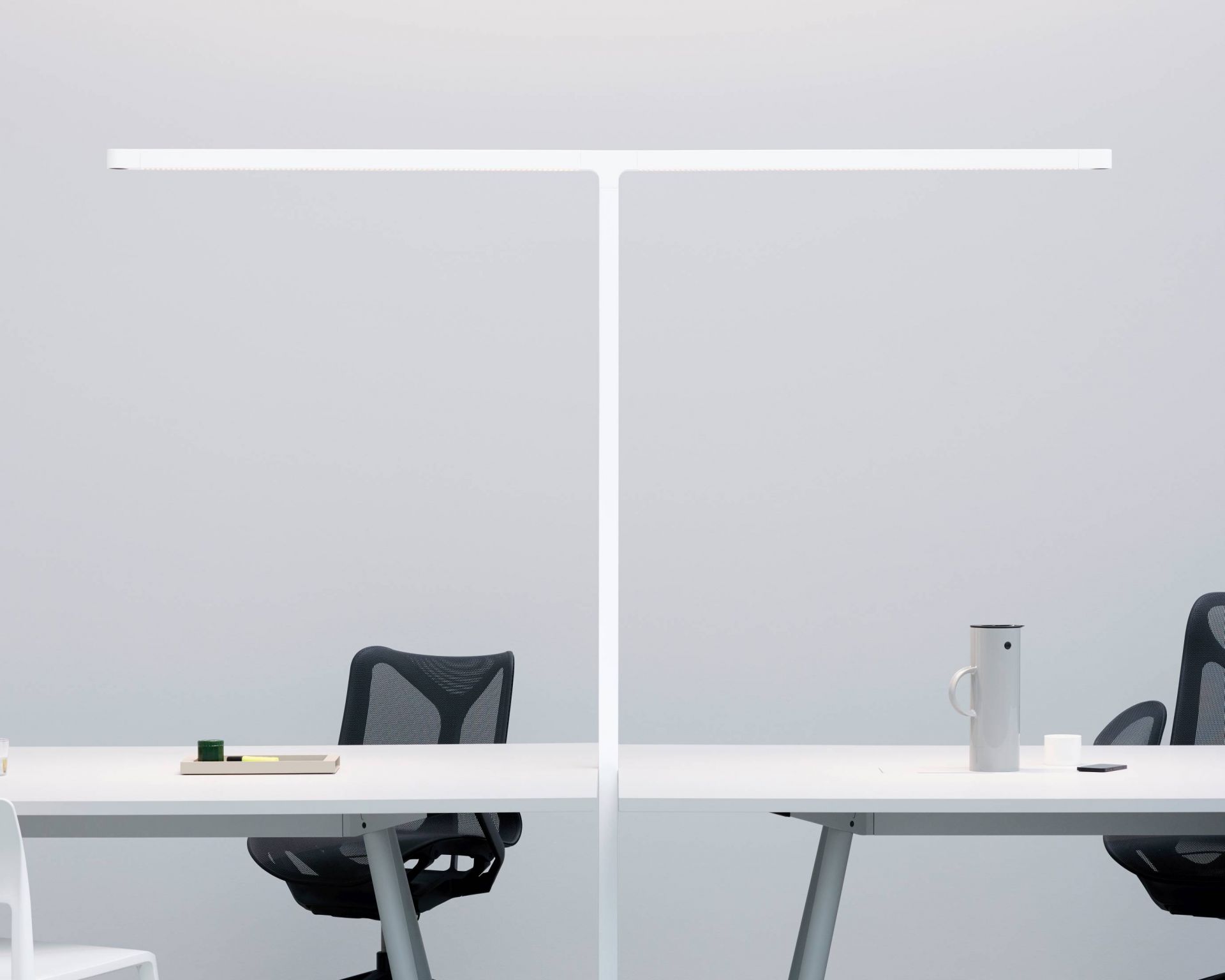 Team Cowork Stehleuchte in Grau über zwei Schreibtische mit Bürostuhl und Accessoires, modernes Büromöbel Design.