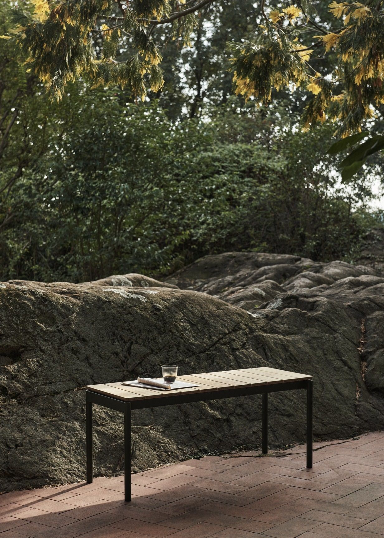 AndTradition Ville AV26 Outdoor Tisch aus Teakholz und schwarzem Metallgestell im Garten.