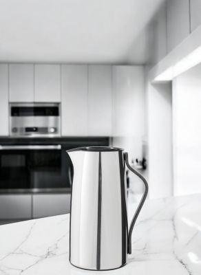 Emma Isolierkanne aus Edelstahl von Stelton auf einer Marmoroberfläche in einer modernen Küche.