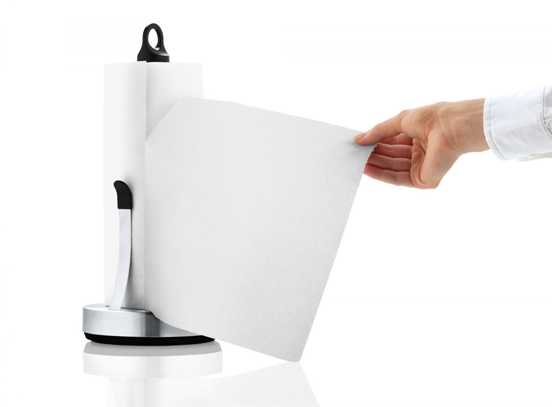 Blomus Loop Küchenrollenhalter: Hand reißt ein Blatt Küchenpapier von der Rolle ab.