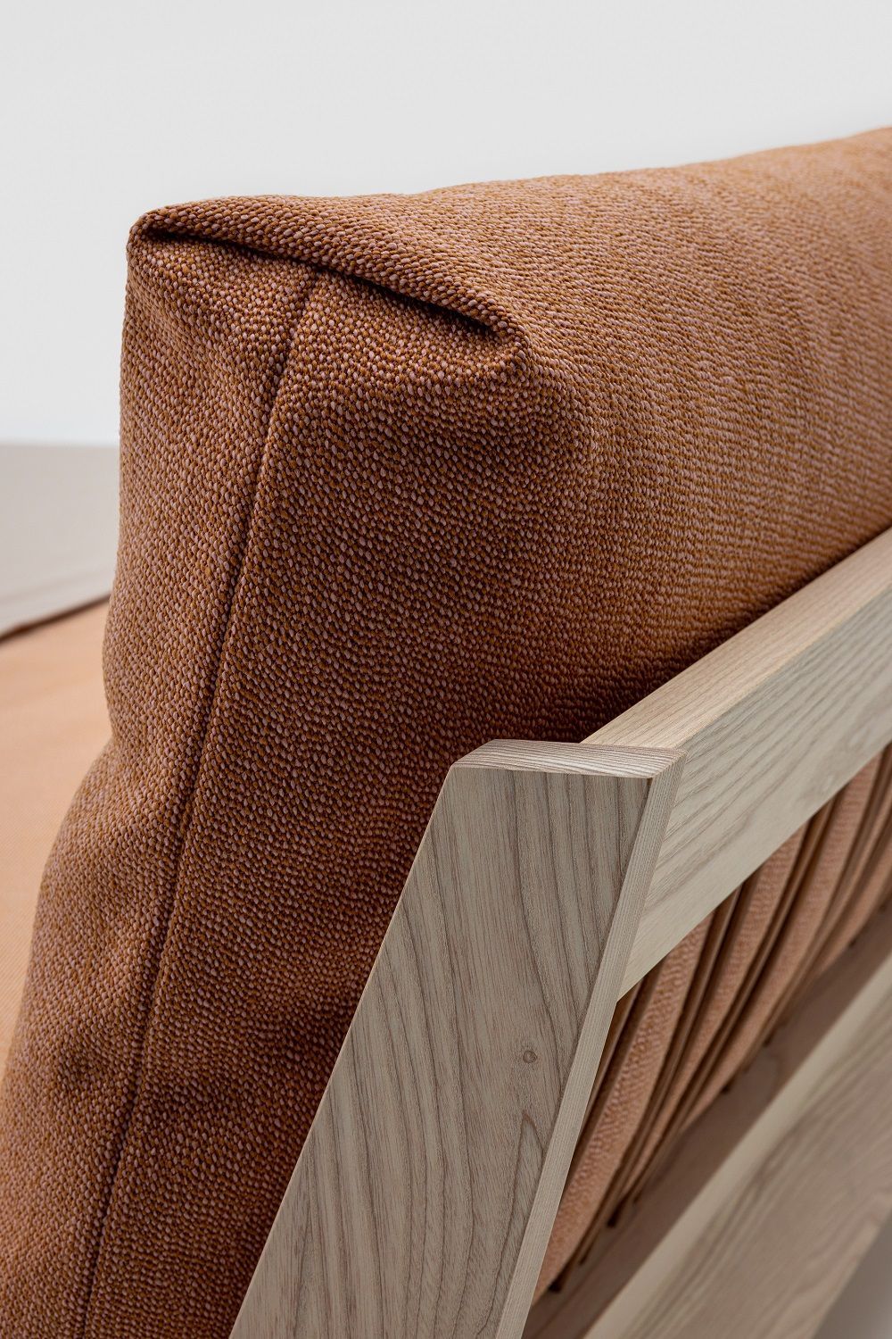 Detailaufnahme: Mellow Bett Massivholz, helles Holzgestell und braunes, strukturiertes Kopfteil. Hochwertiges Schlafzimmermöbel.