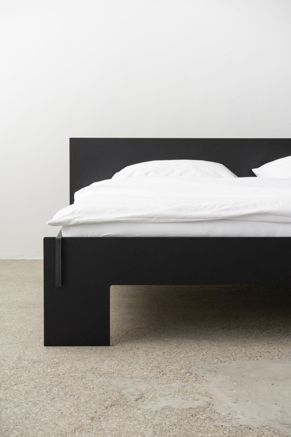 Schwarzes Siebenschläfer Bett mit Kopfteil von Moormann, Größe 160x200 cm, mit weißer Bettwäsche.