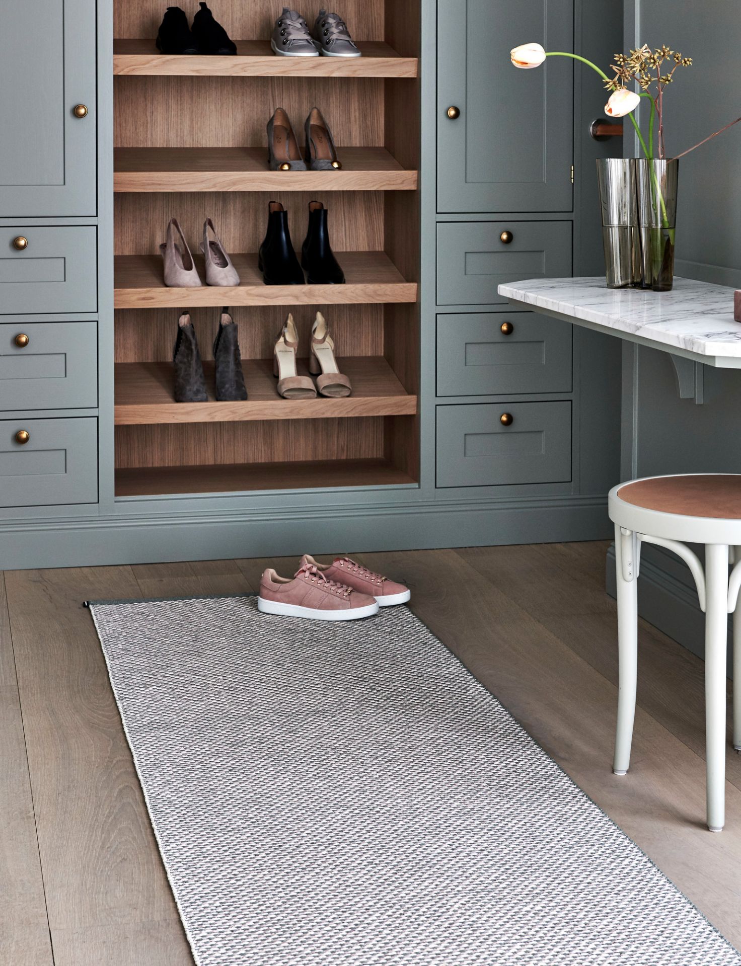 Effi Kunststoffteppich von Pappelina, 70x200 cm, grau-weißes Muster, im Flur vor einem Schuhschrank.