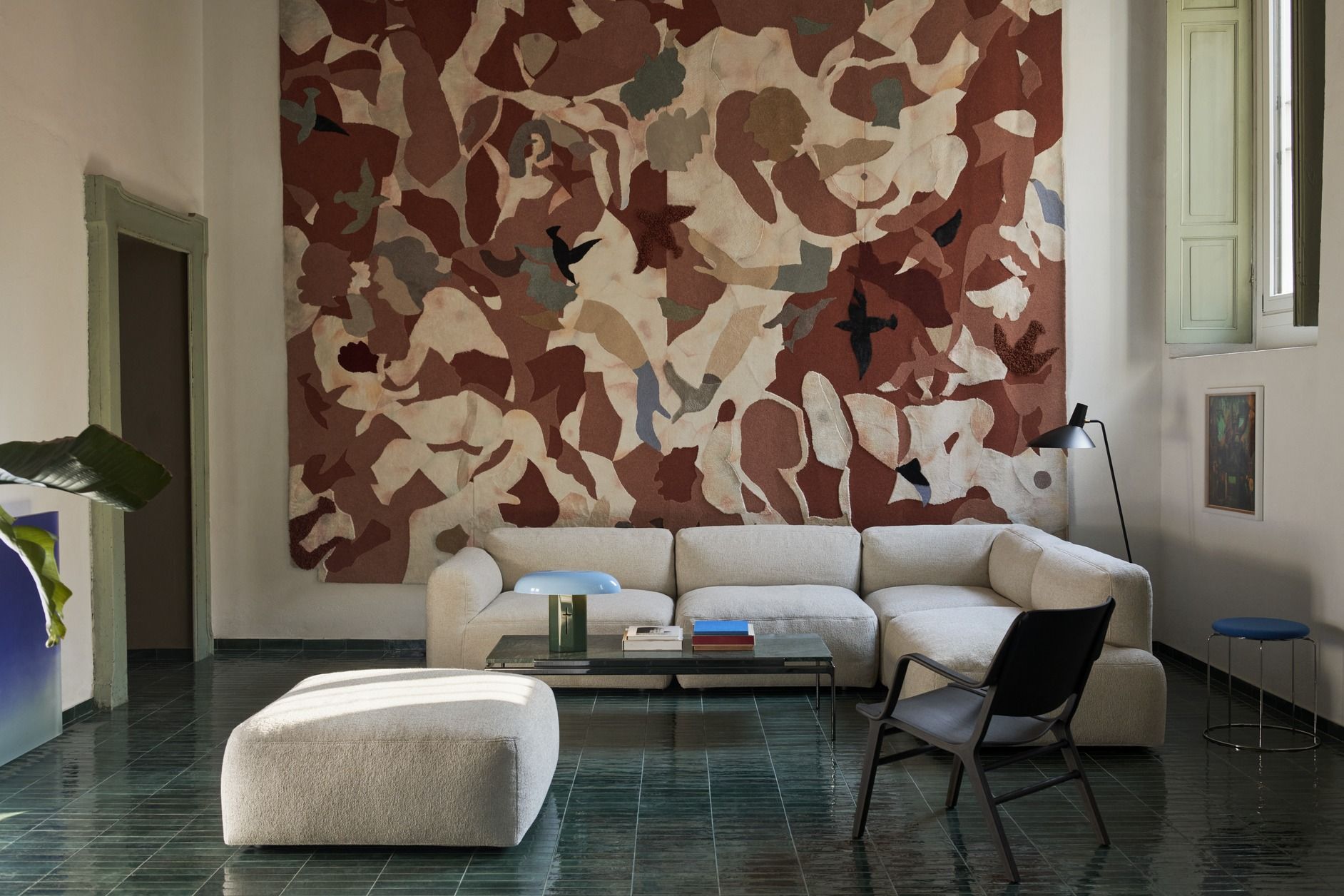 Wohnzimmer mit Sett Couchtisch von AndTradition, beigem Sofa, Teppich und grünen Fliesen.