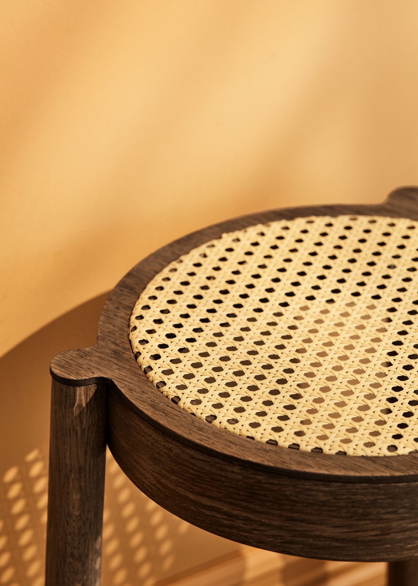 Detailansicht des Pal Hockers: Geräucherte Eiche mit hellem Netzgewebe von Northern. Stapelbarer Hocker.