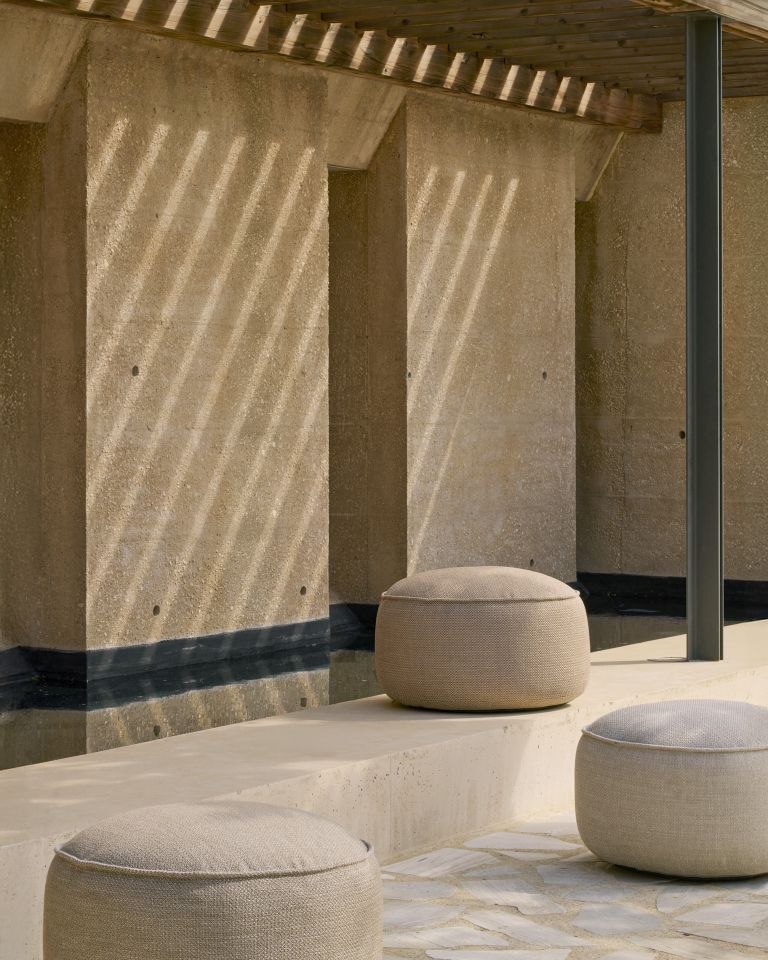 Drei beige Donut Outdoor Sitzhocker von Ethnicraft auf einer Terrasse im Freien.