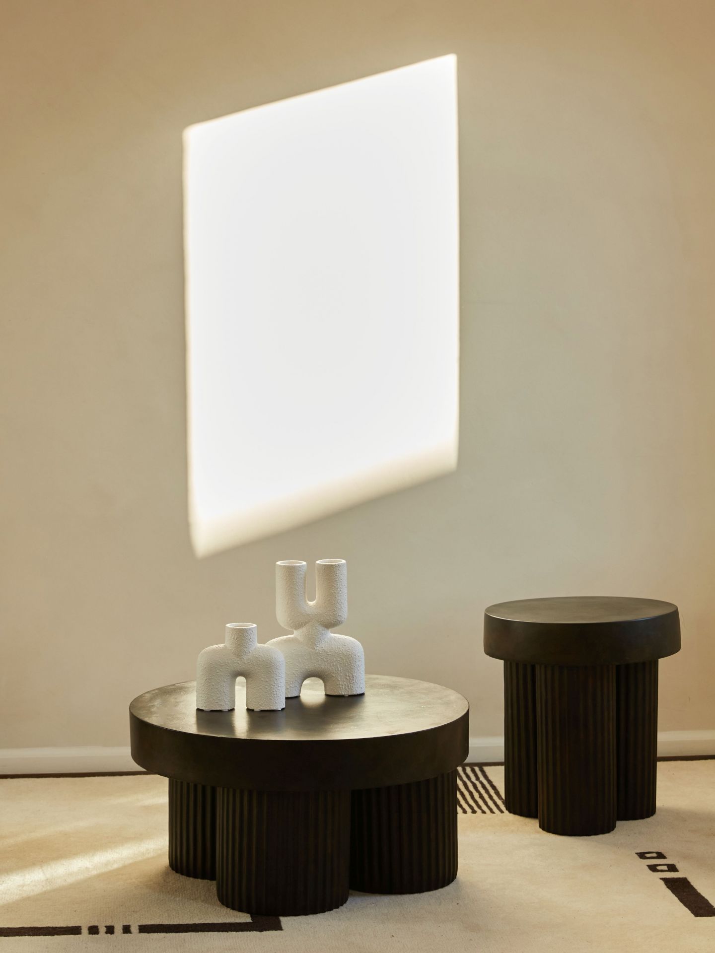 Gear Beistelltisch von Norr11 in dunklem Holz, mit dekorativen Vasen auf einem Teppich.