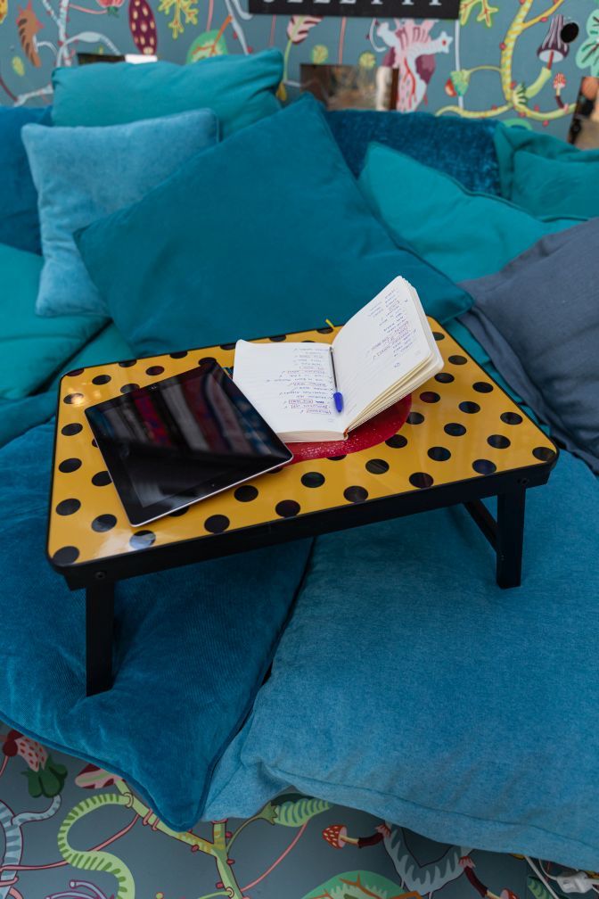 Seletti Toiletpaper Sofa Tray Tablett mit Tablet und Notizbuch auf blauen Kissen.