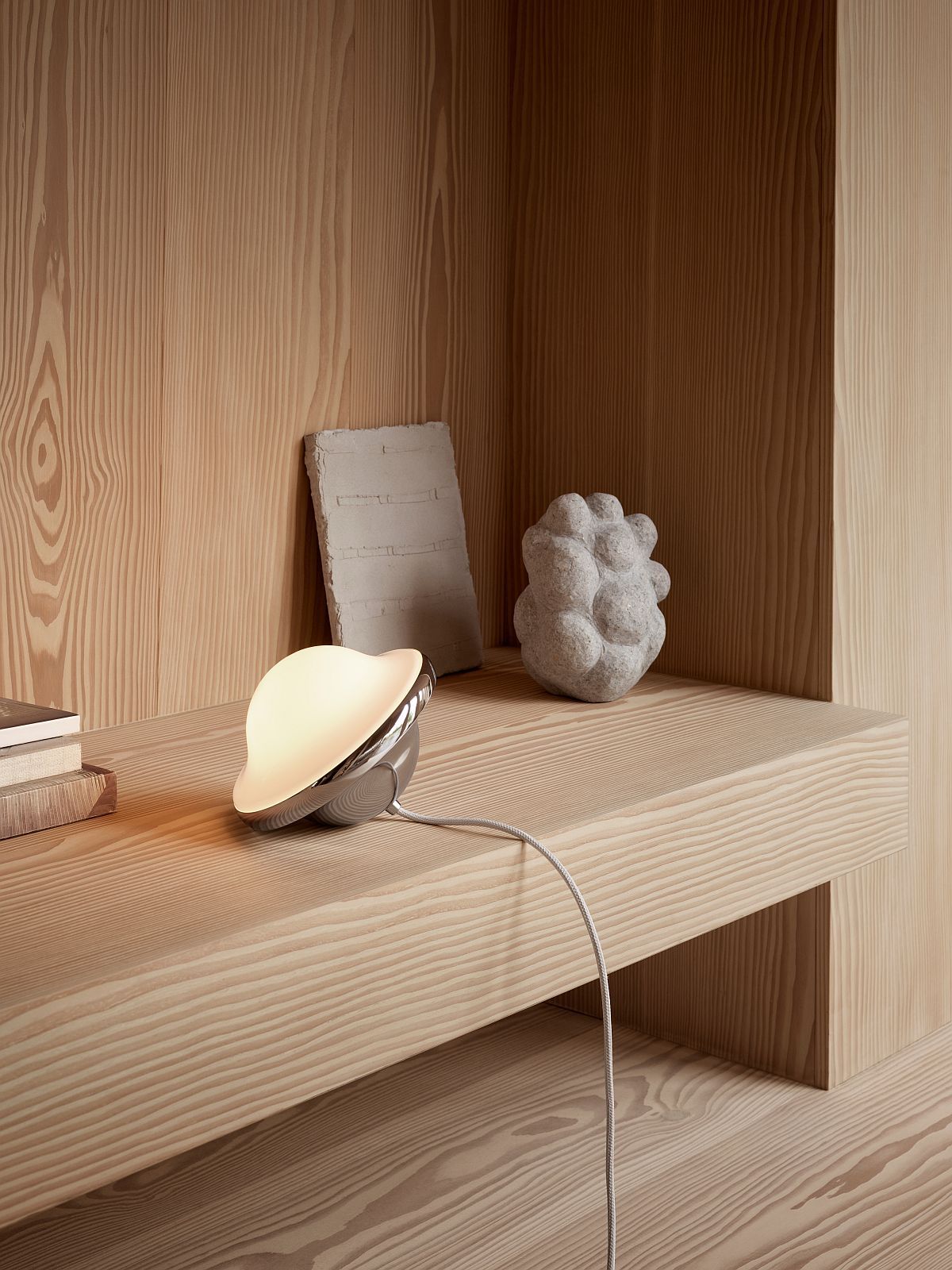 HK20 Bubi Tischleuchte von Carl Hansen & Søn auf Holzregal, modernes Design, warmes Licht.