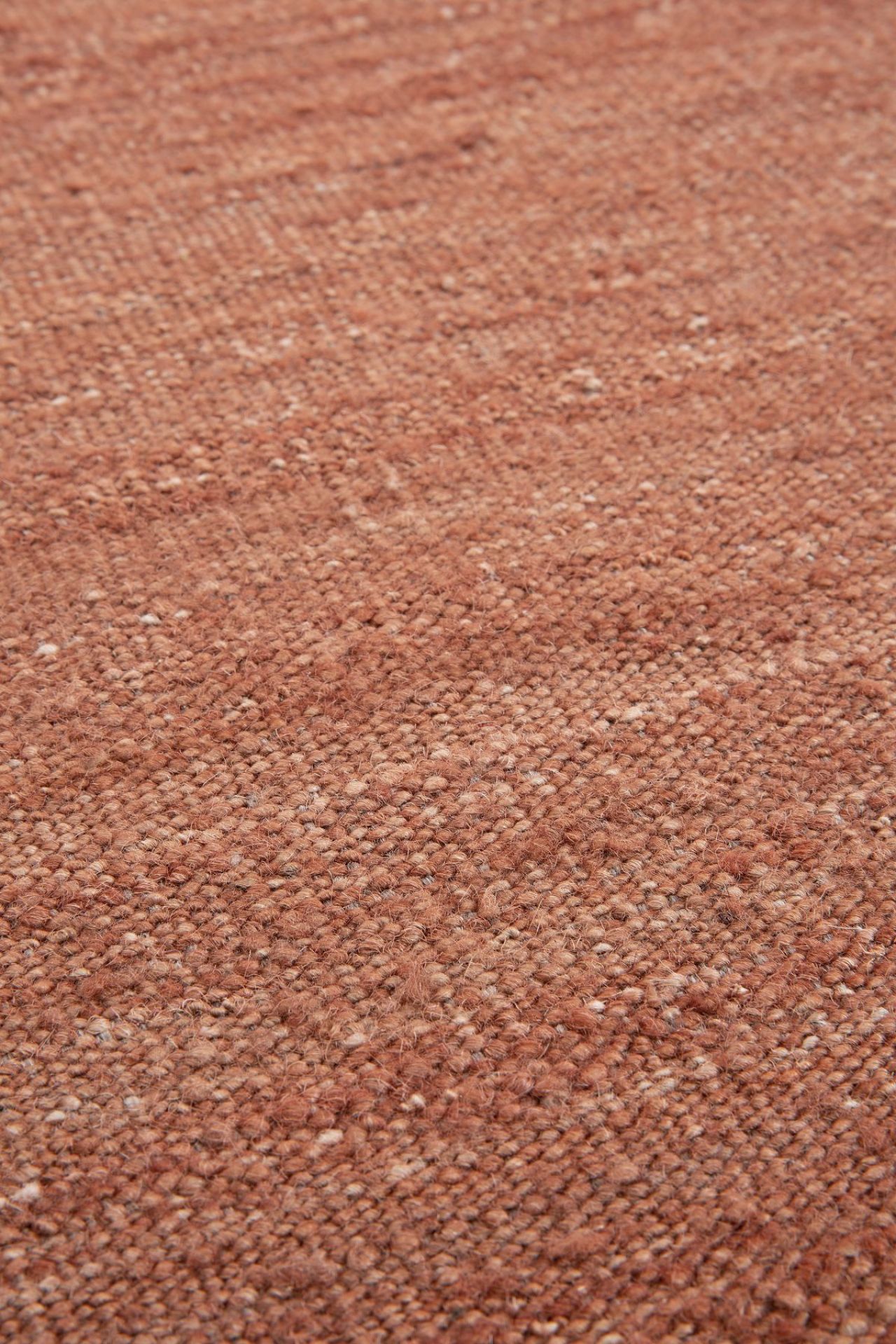 Detailaufnahme des Terracotta Nomad Kilim Teppichs von Ethnicraft, der eine warme, erdige Textur zeigt.