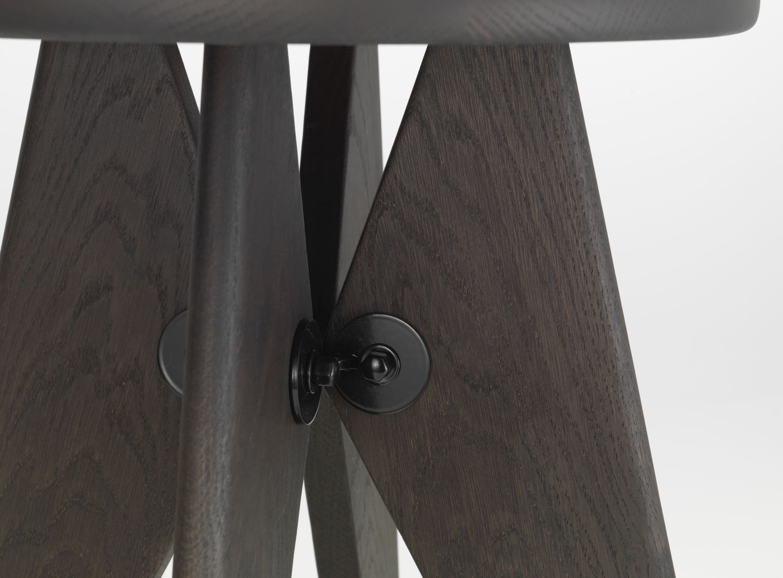Detailaufnahme Tabouret Solvay Hocker: Dunkle Eiche, massive Holzbeine mit schwarzer Metallverbindung.