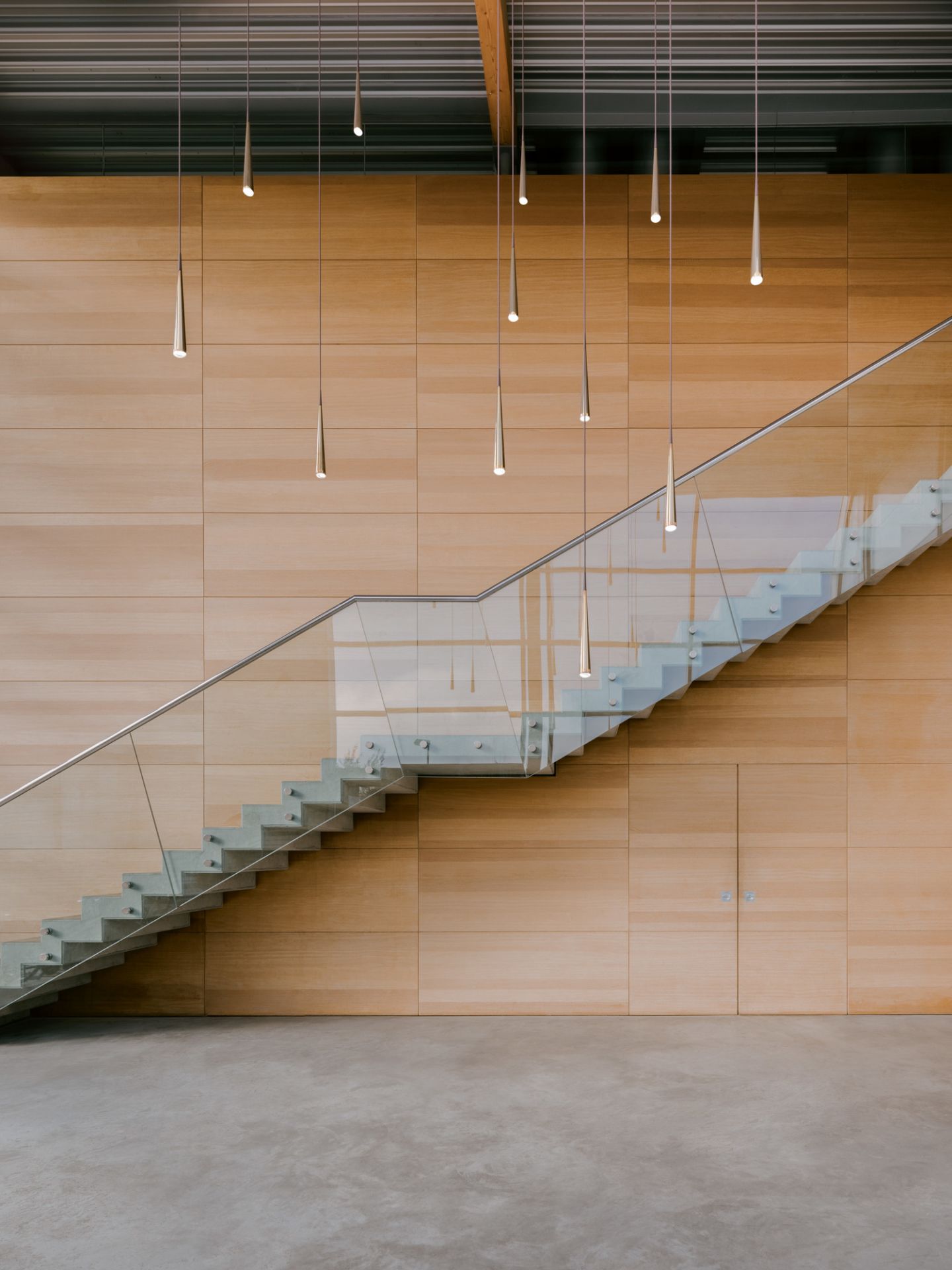 Moderne graue Pendelleuchten im Raum mit Treppe und Holzwand, Niceone Leuchte.