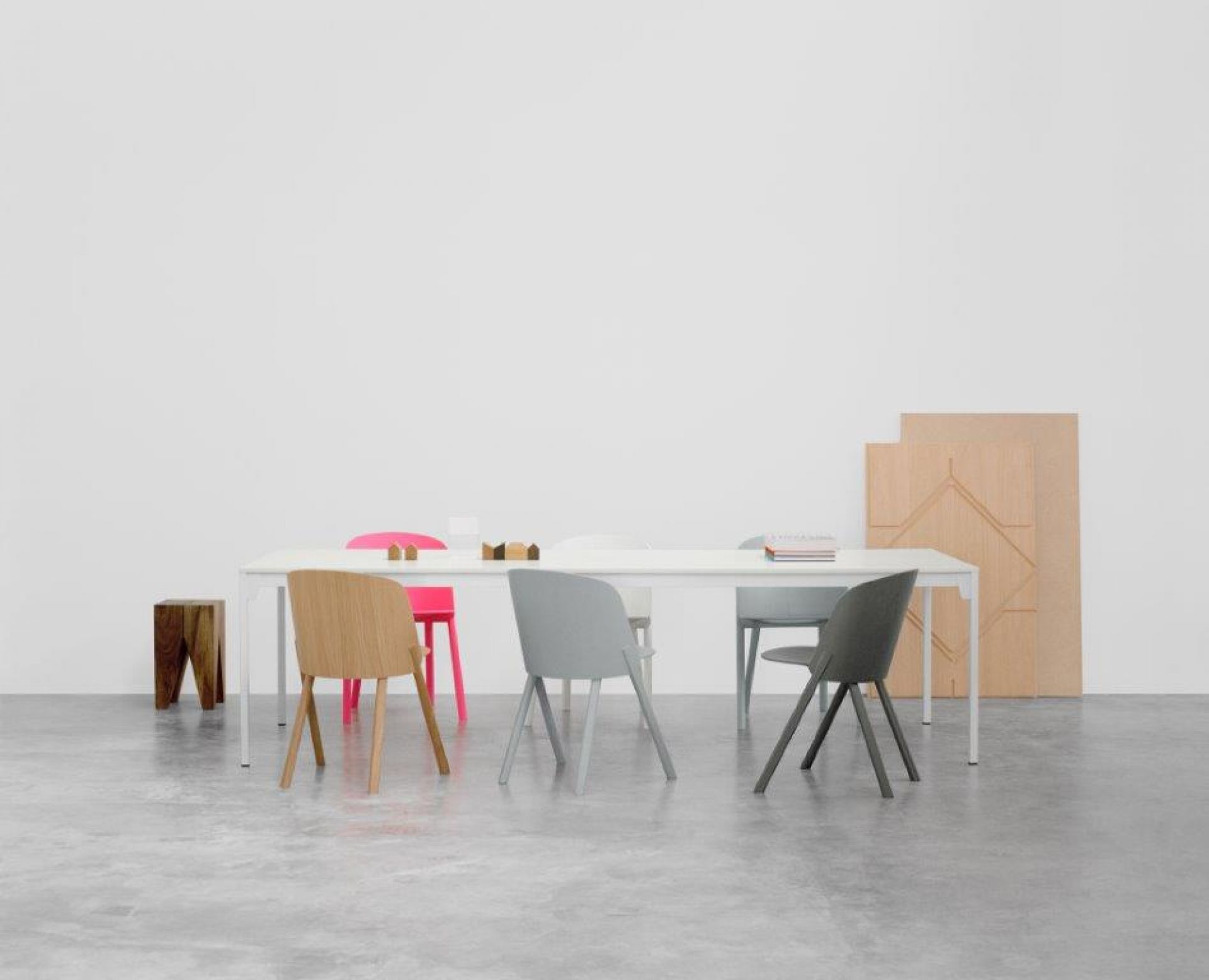 CH05 Stühle von e15 in verschiedenen Farben um einen weißen Esstisch gruppiert.