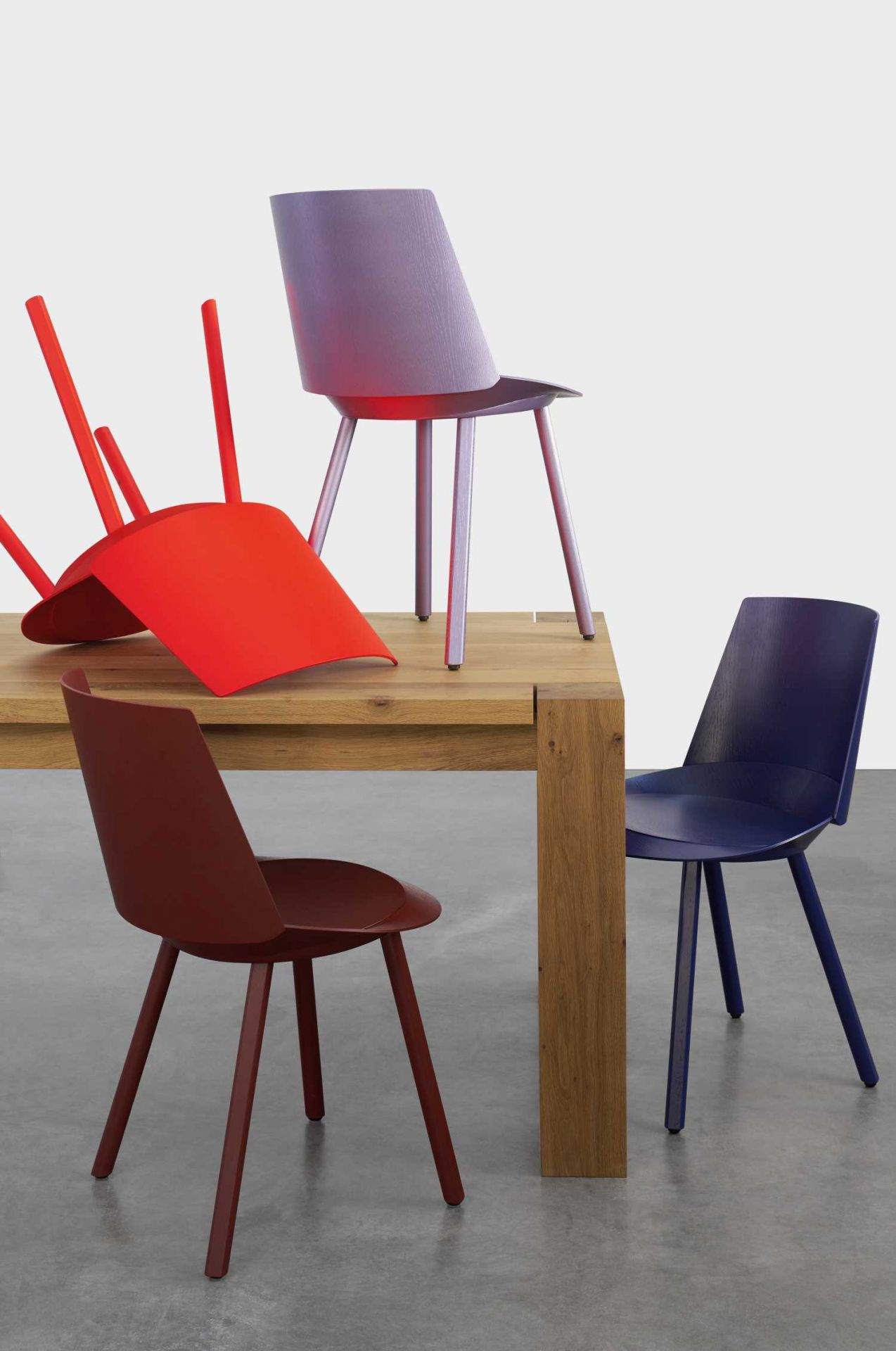 TA04 Bigfoot Tisch e15 mit farbigen Stühlen in Rot, Lila, Braun und Blau.