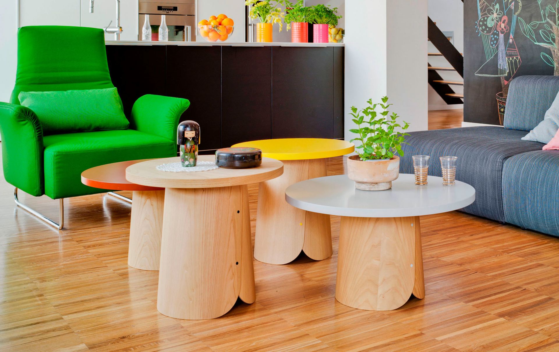 Mehrere Sancal Tab Beistelltische in Orange, Gelb und Weiß im modernen Wohnzimmer. Holztisch mit Pflanze.