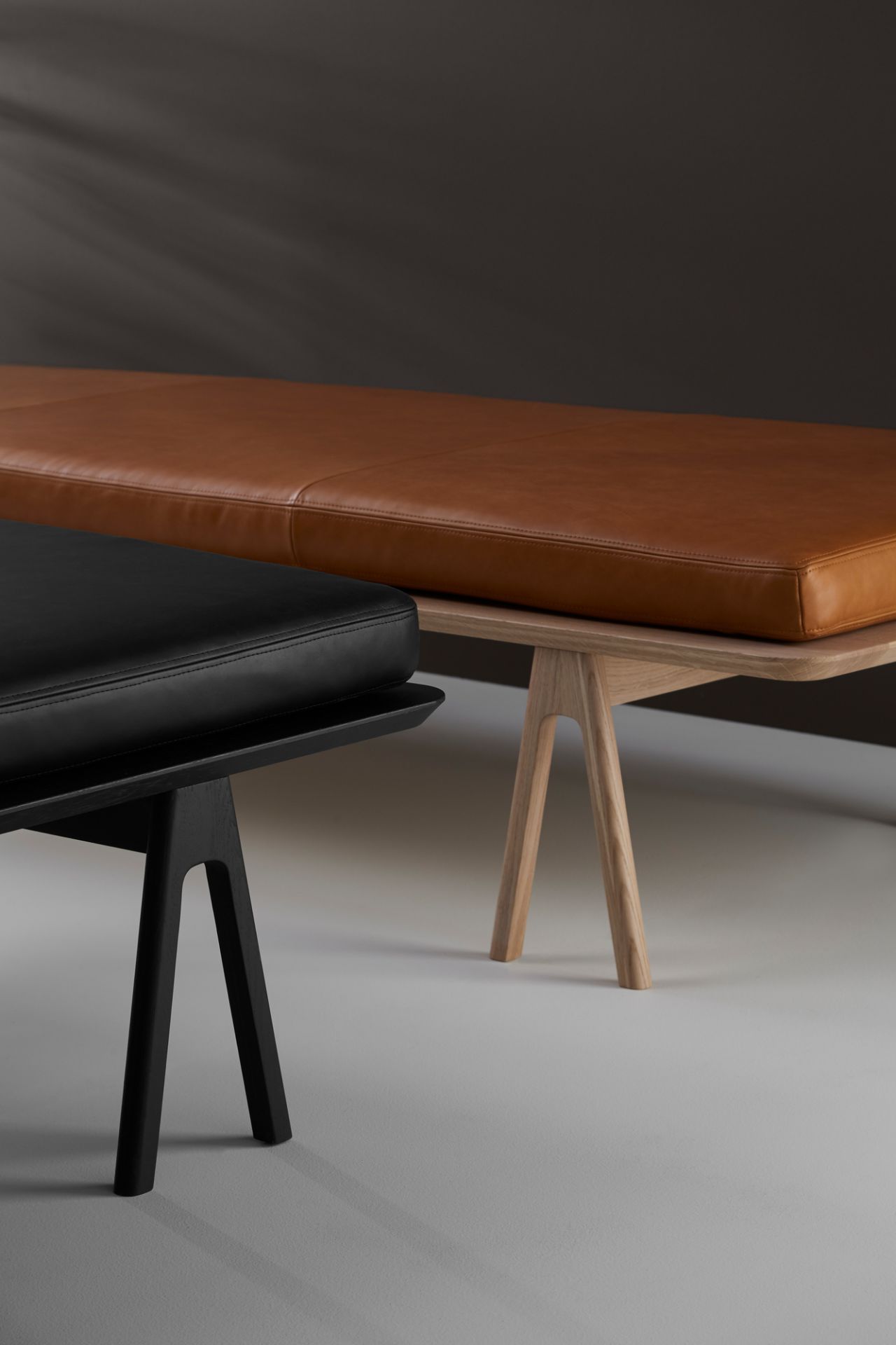 Detailaufnahme: Schwarze und braune Level Daybeds von Woud mit Holzgestell.