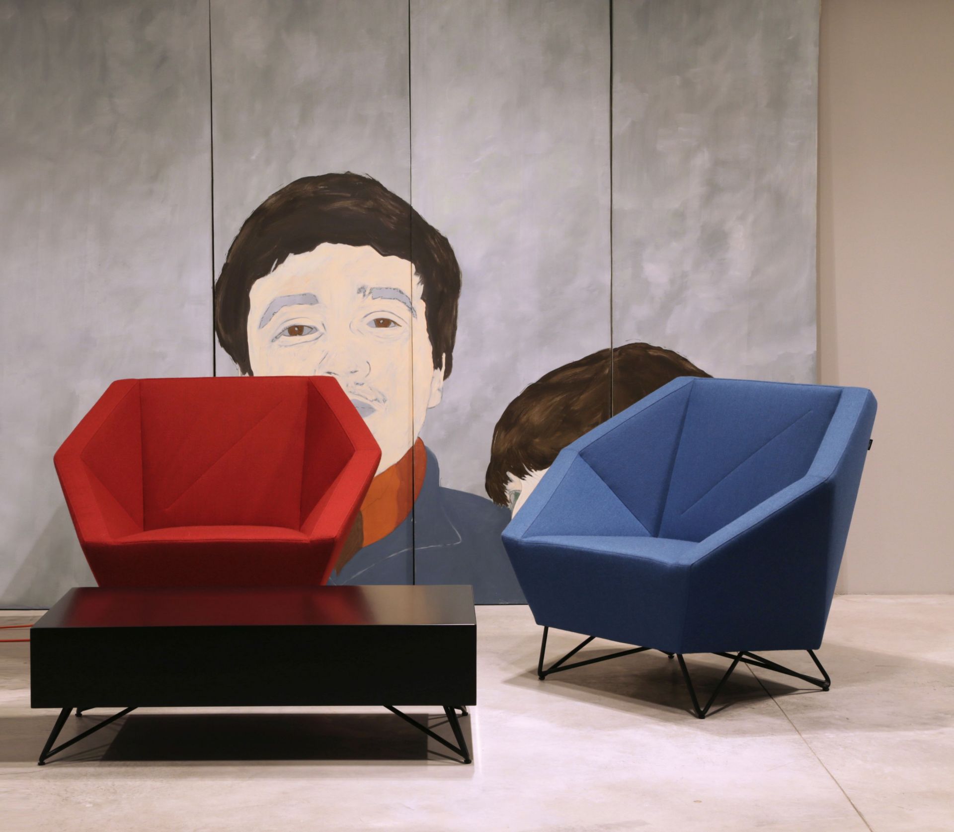 Roter und blauer 3angle Armsessel von Prostoria mit schwarzem Tisch vor Kunstwerk.