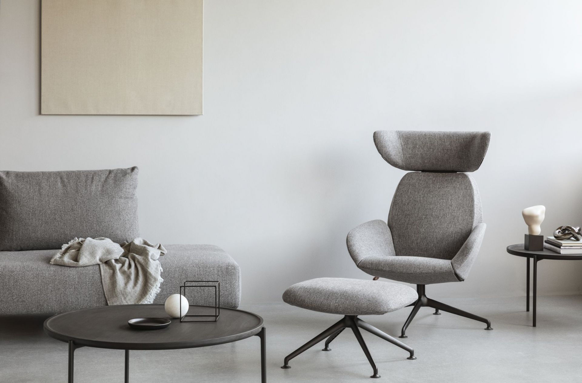 Grauer Laze Fußhocker von Eva Solo mit schwarzem Fußkreuz in modernem Wohnzimmer.