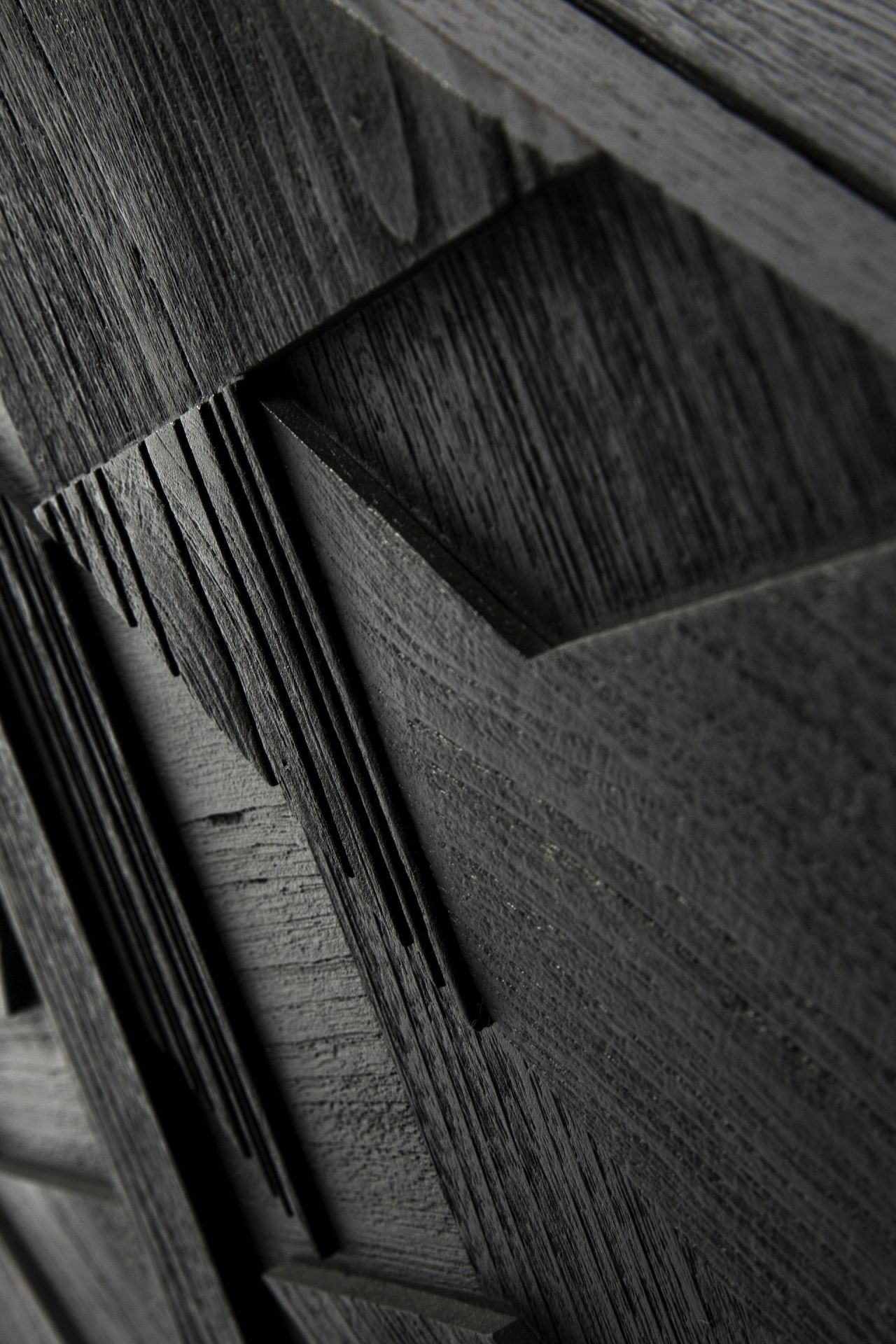 Detailaufnahme der schwarzen Graphic Teak Anrichte von Ethnicraft mit grafischem Muster und Holzstruktur.