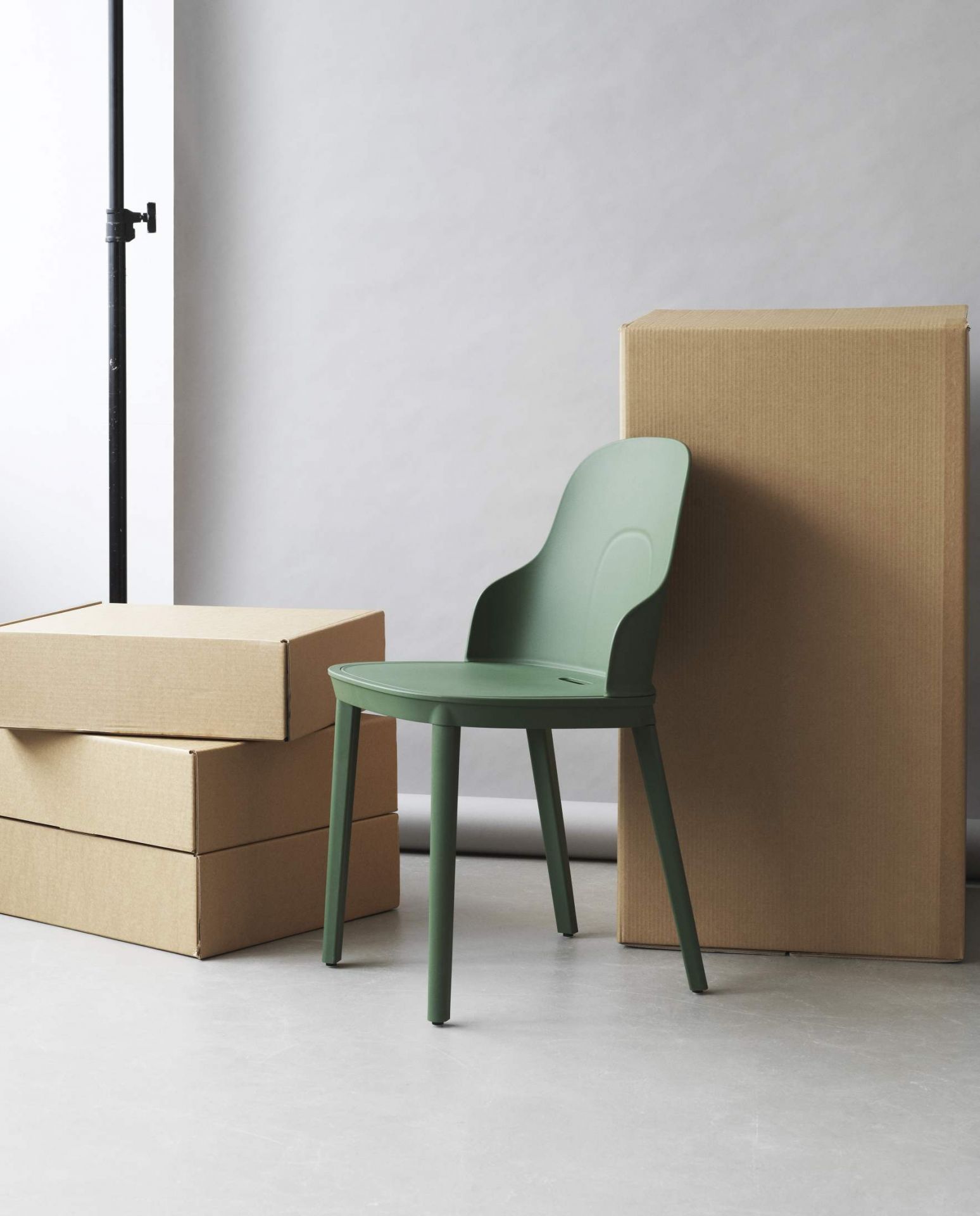 Grüner Allez Chair von Normann Copenhagen vor Kartons, moderner Stuhl für Esszimmer.